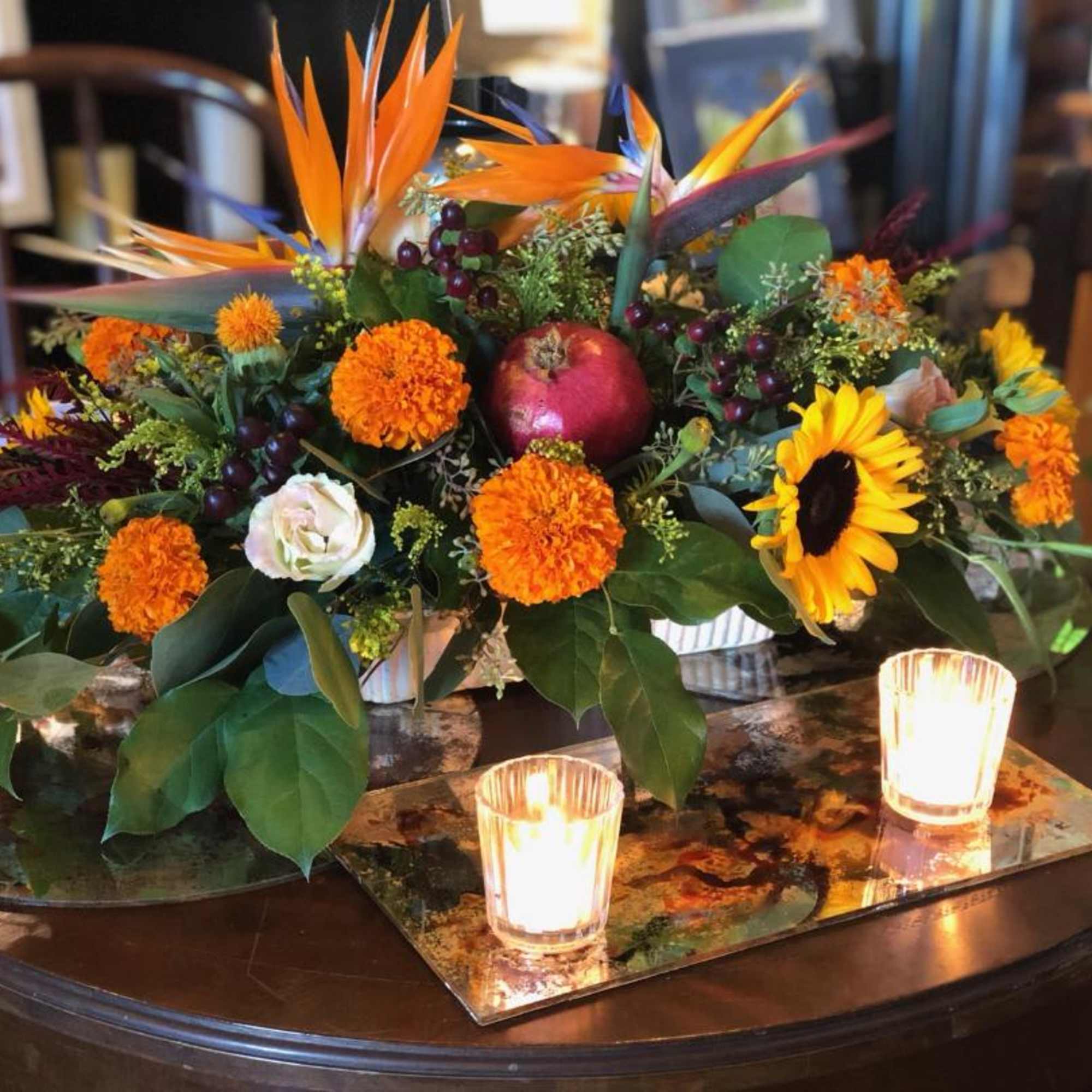 Birds of paradise crown this centerpiece surrounded by fall favorites; sunflowers, orange