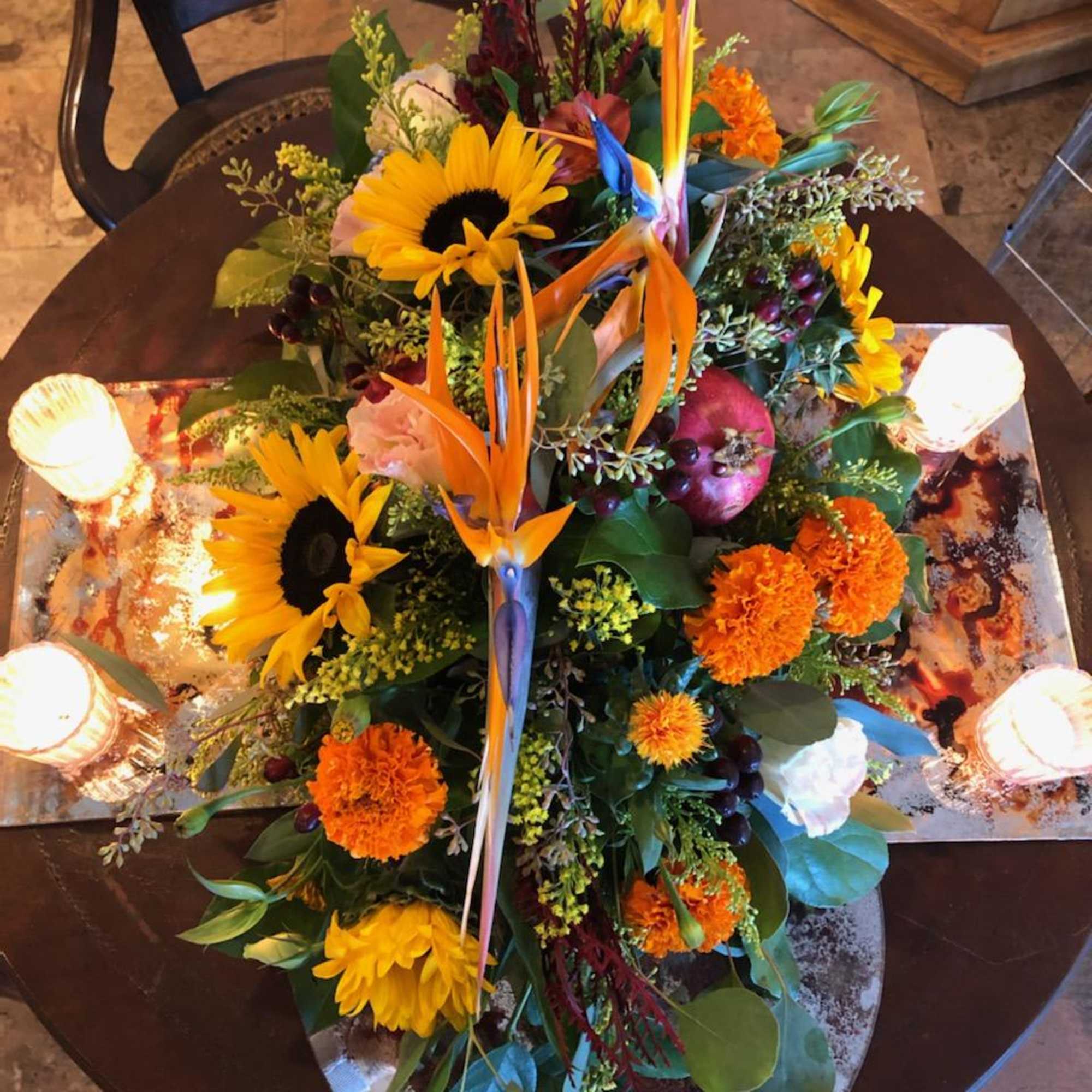 Birds of paradise crown this centerpiece surrounded by fall favorites; sunflowers, orange
