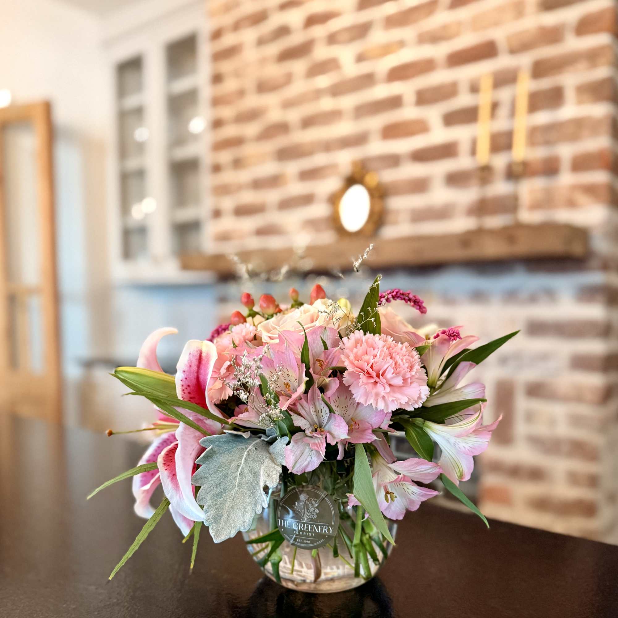 This soft display of pink carnations, alstromeria, pink lily, and pink roses