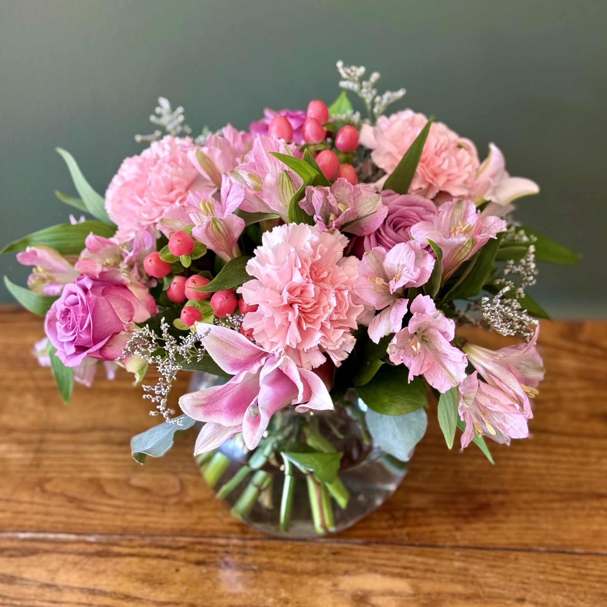 This soft display of pink carnations, alstromeria, pink lily, and pink roses