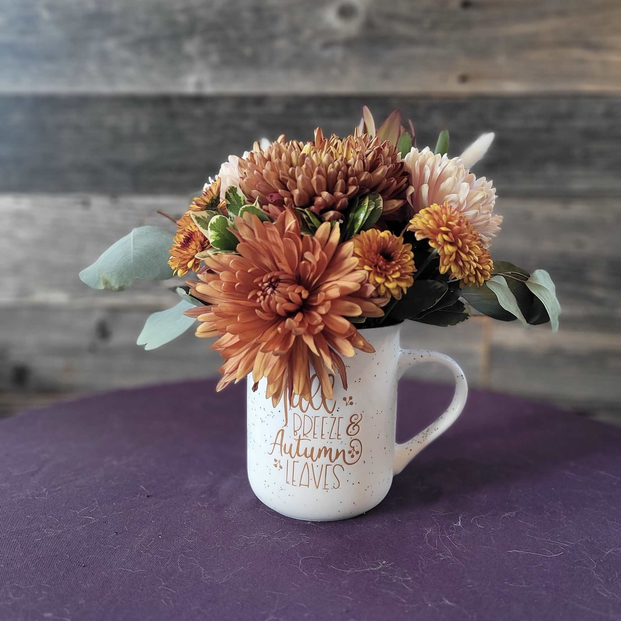 This charming floral arrangement is designed in a keepsake mug and paired