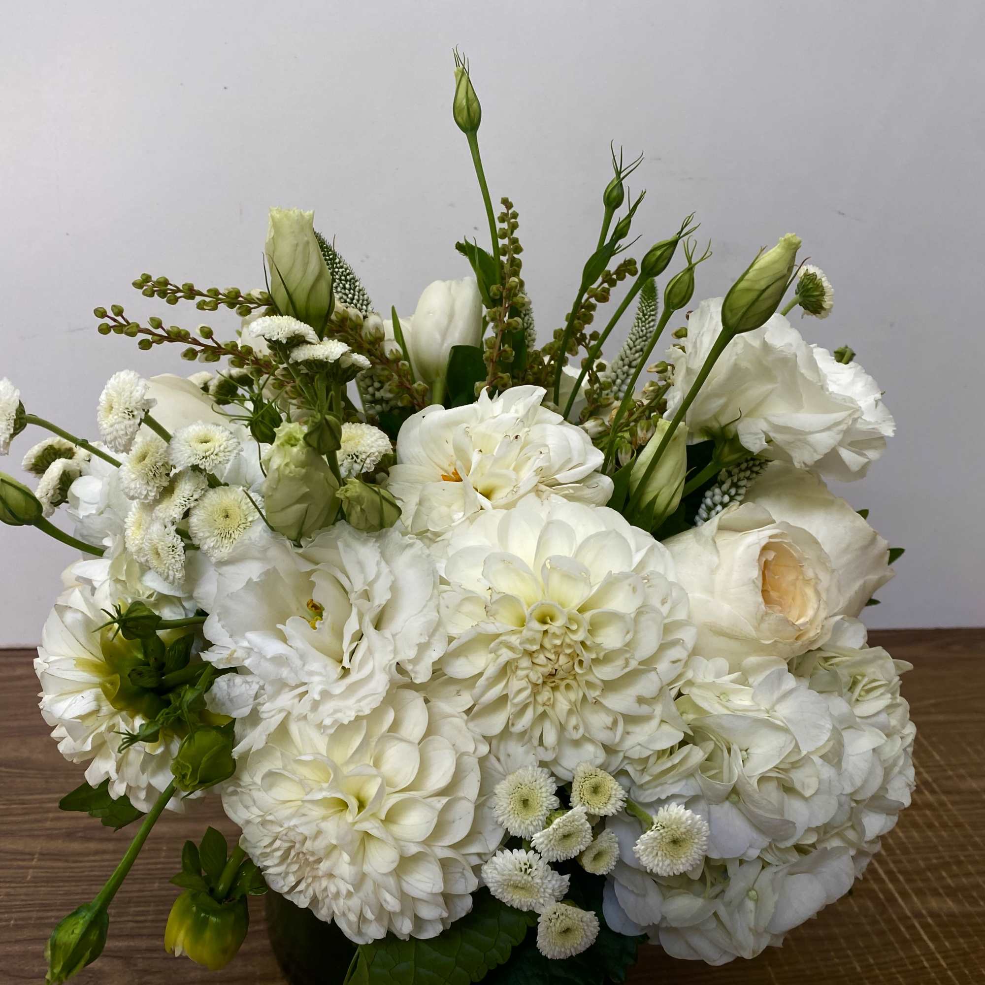glass vase with a white hydrangea, white dahlia, garden roses and white