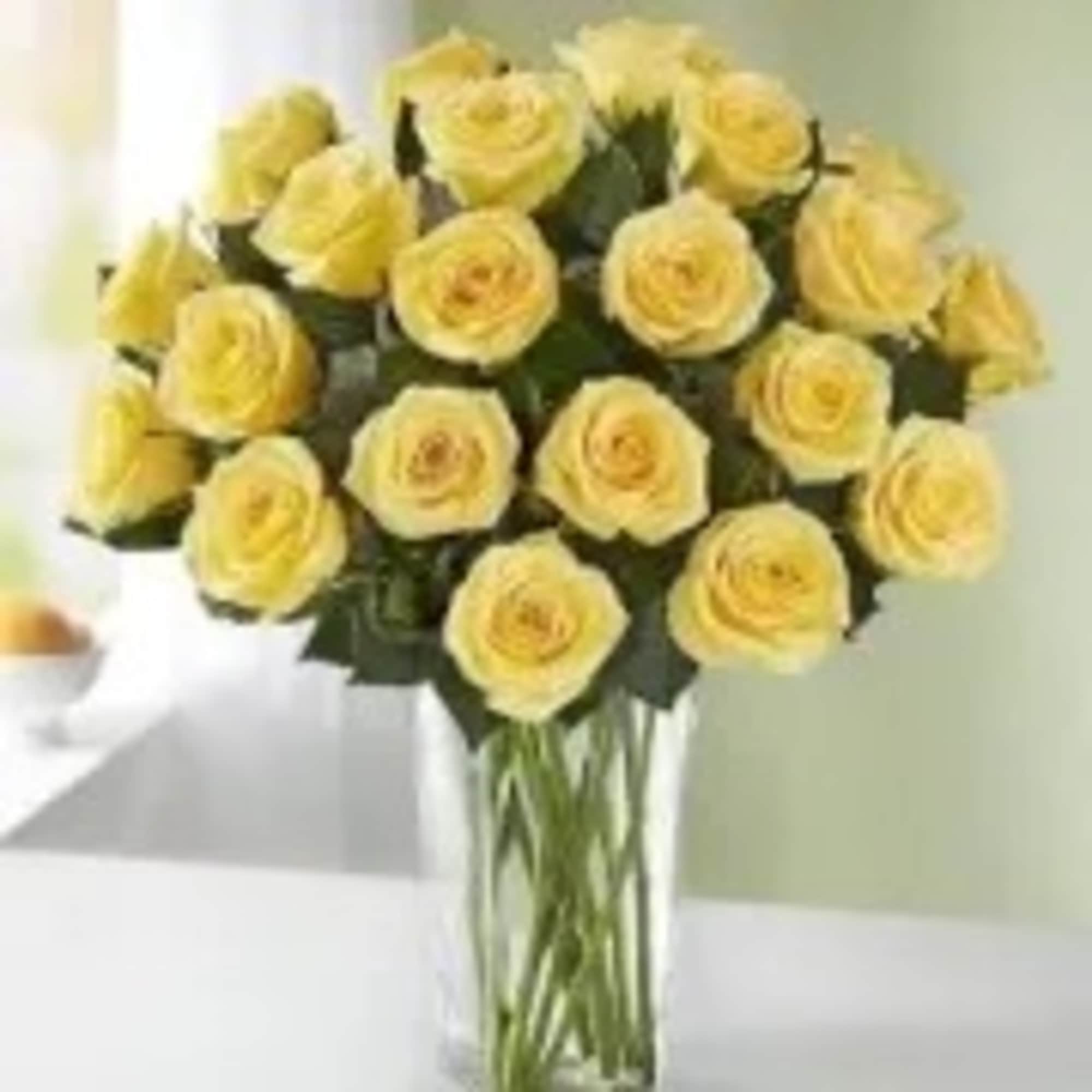 Dozen yellow roses in a clear glass vase