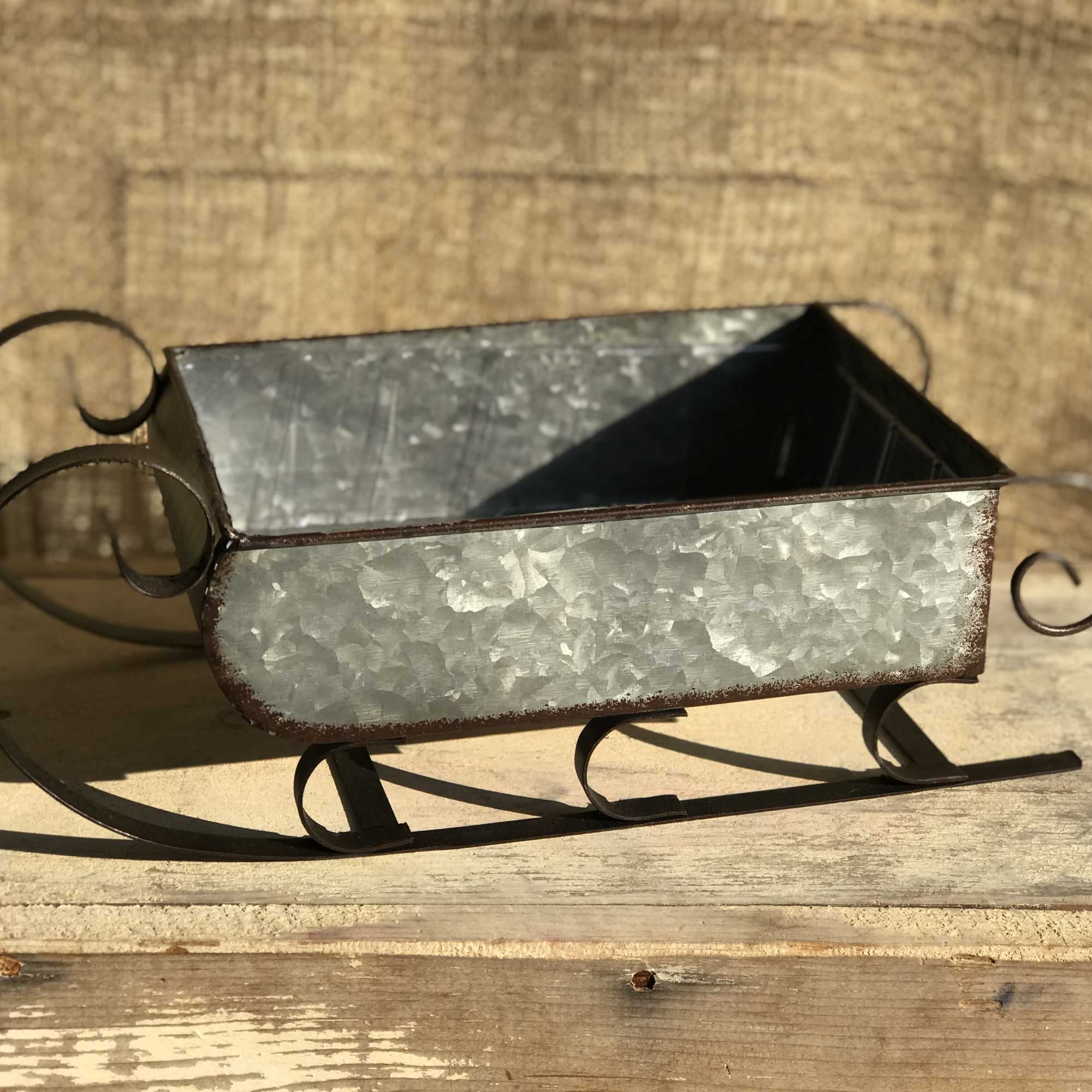This metal sleigh carries an assortment of fragrant evergreens, assorted red and