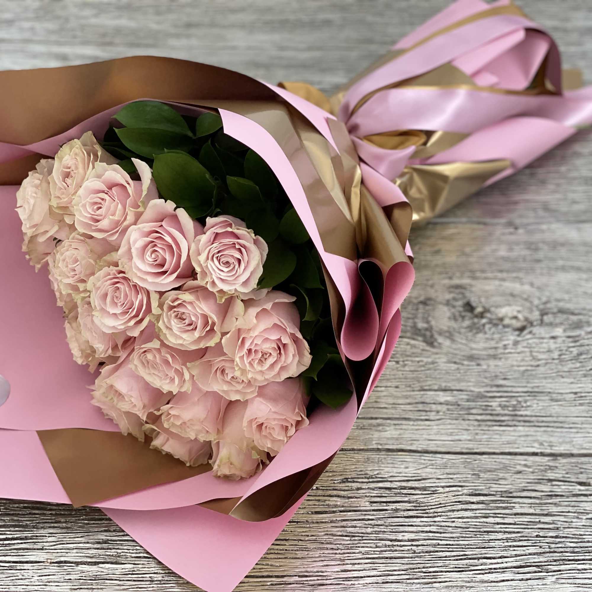 This bouquet features two dozen soft blush pink roses, gathered with lush