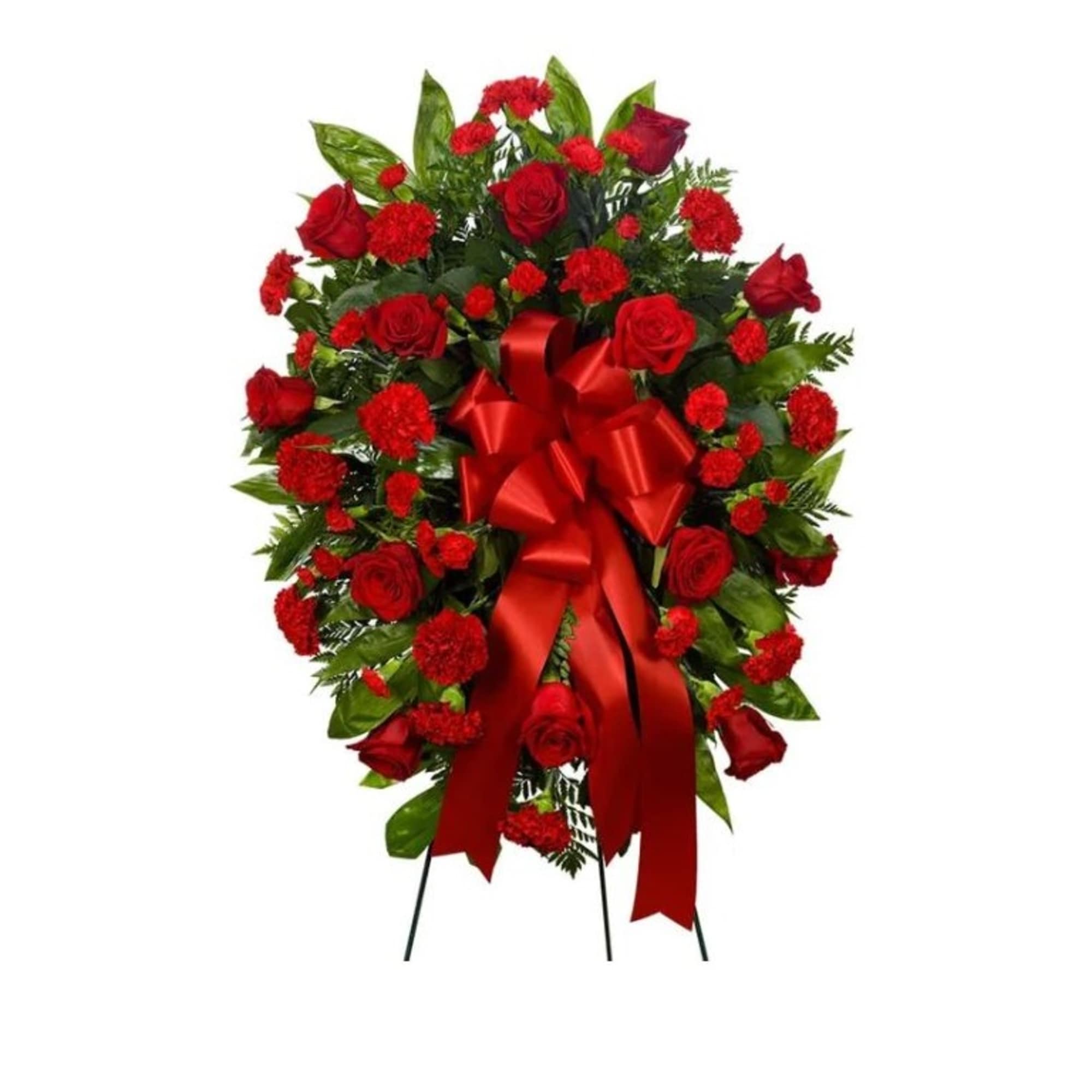 A standing spray of red roses and red carnations on a bed