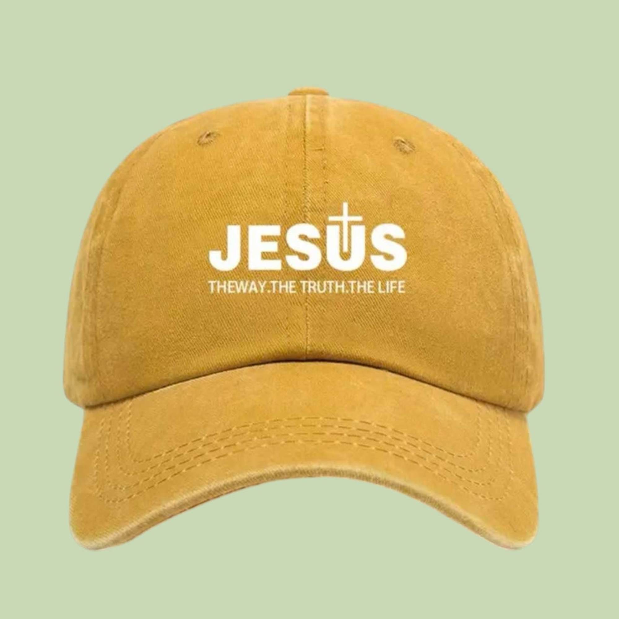 Bold and meaningful, this mustard yellow cap features JESUS with a cross