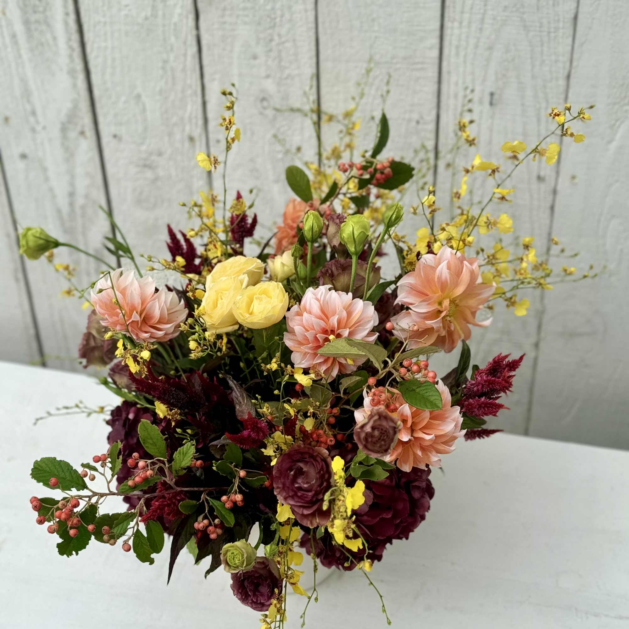 A stunning arrangement with the most beautiful hydrangeas, dahlias,orchids, fall berries, garden