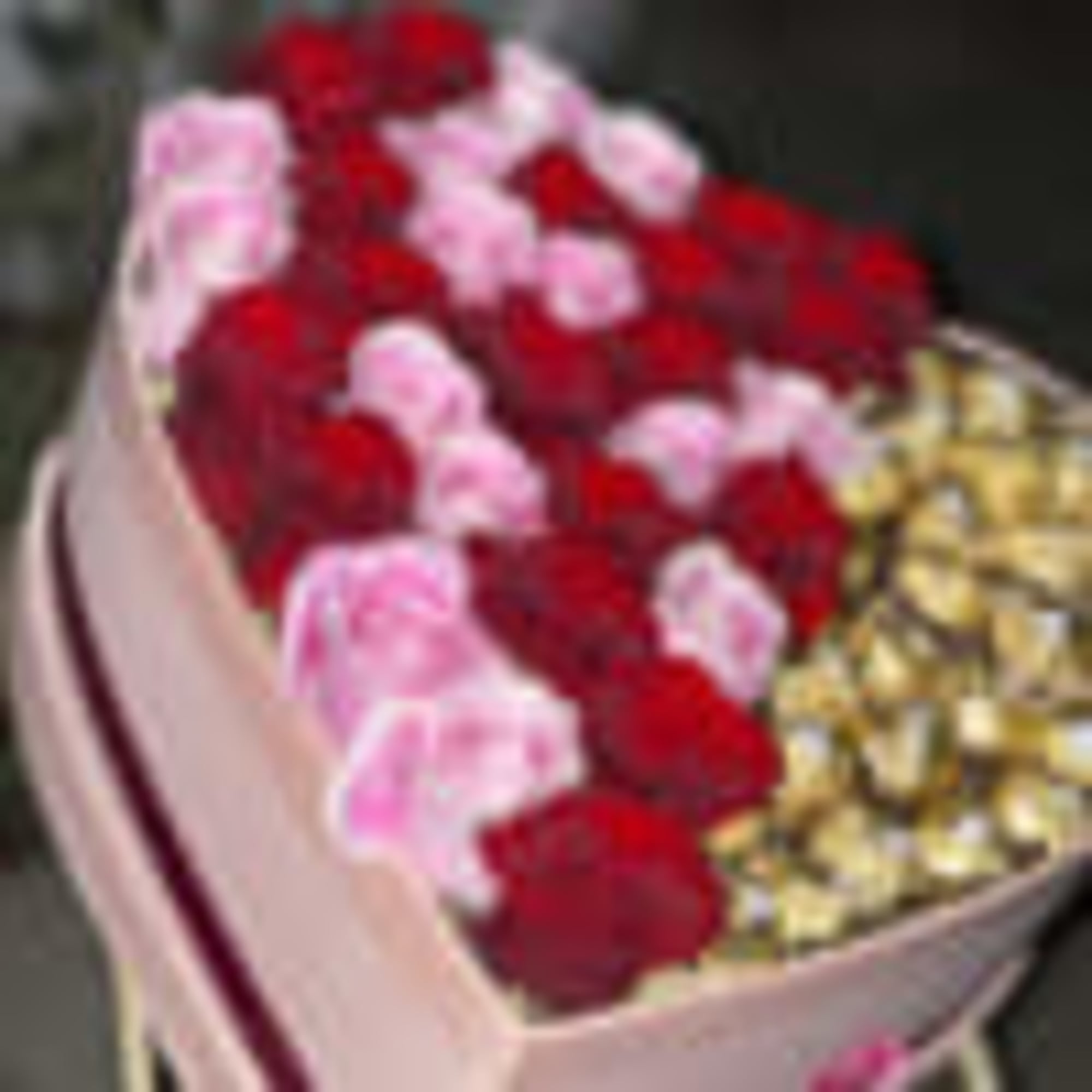 Pink heart shaped box filled with half roses half Ferrero rocker chocolates.