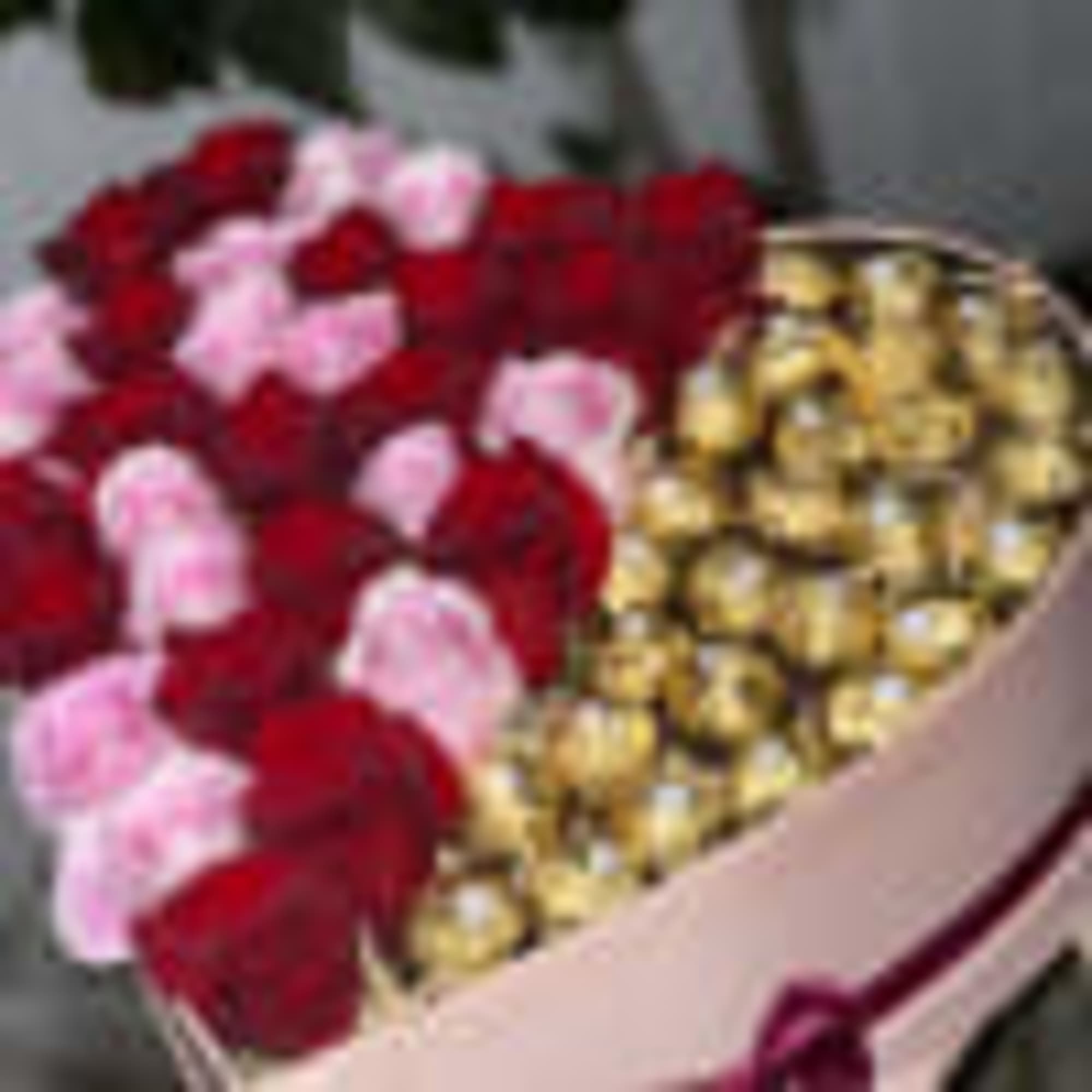 Pink heart shaped box filled with half roses half Ferrero rocker chocolates.