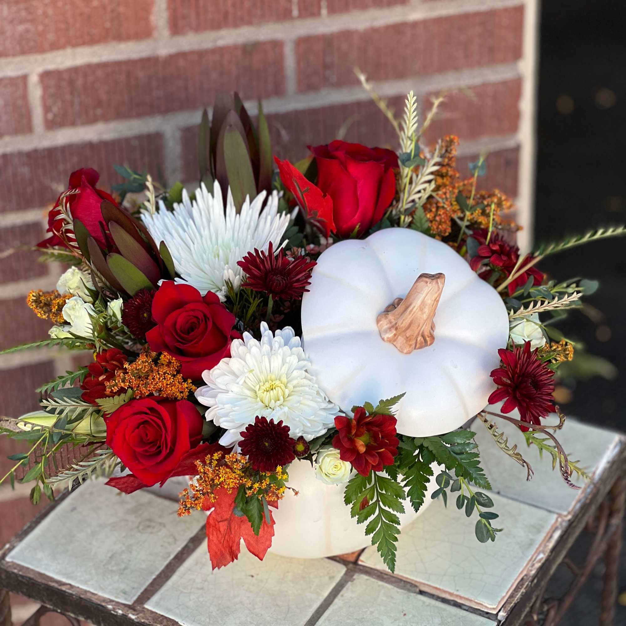 In shades of white, red and fall hues, this white ceramic pumpking