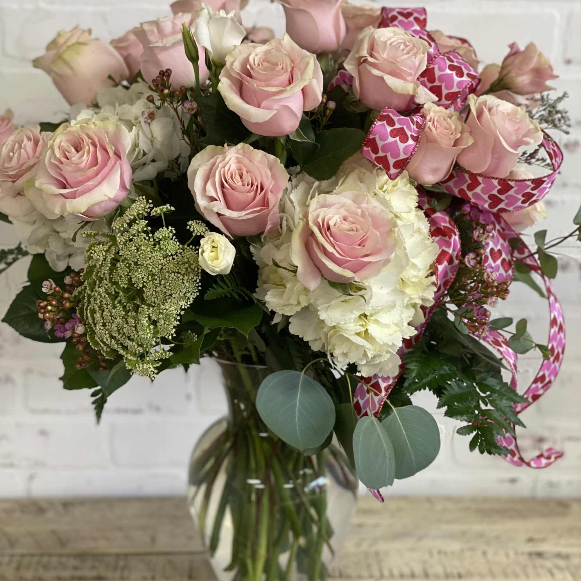 Over a dozen pink mondial roses with hydrangea and filler flowers