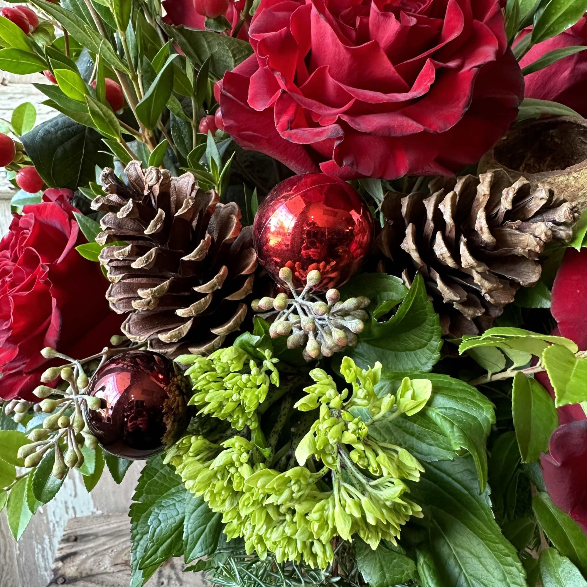 Warm up any home with this festive holiday arrangement! Seasonal fragrant greens