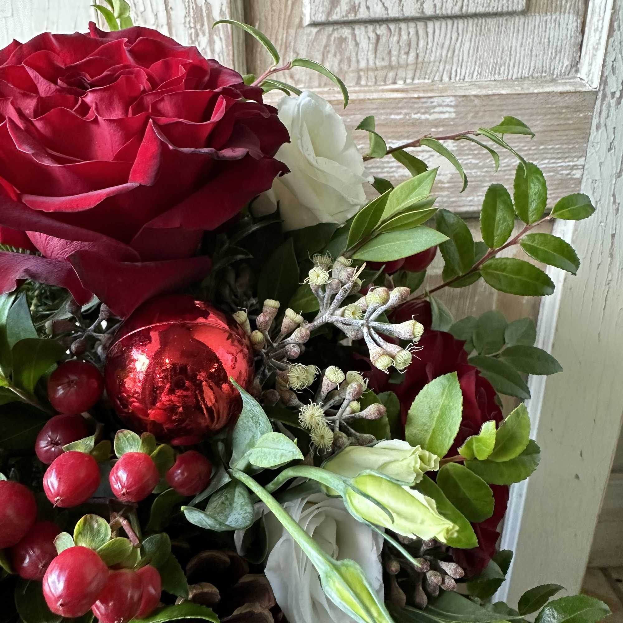 A perfect table centerpiece filled with roses, lisianthus, red hypericum berries and