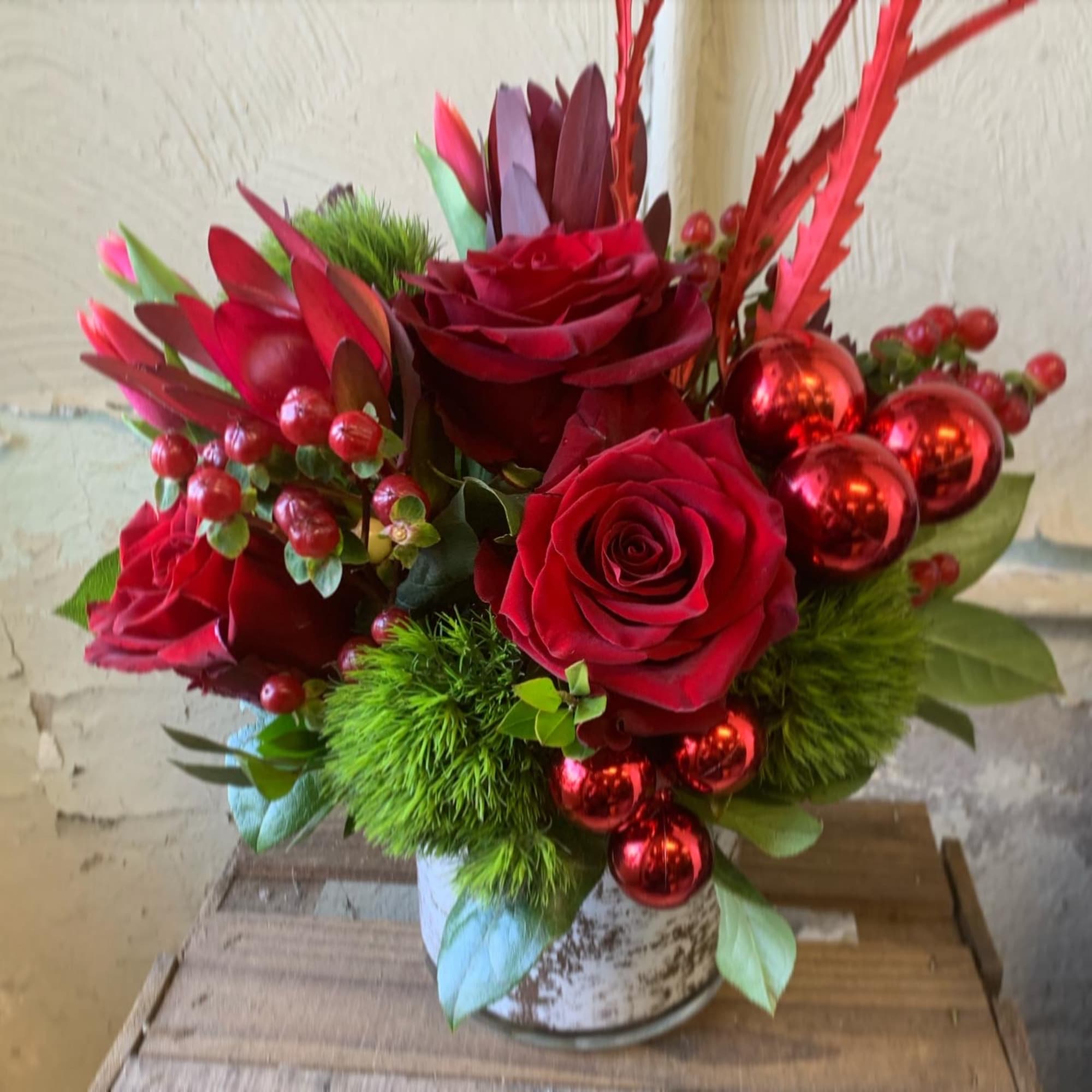 A festive Display of seasonal red roses, berries, balls and evergreens