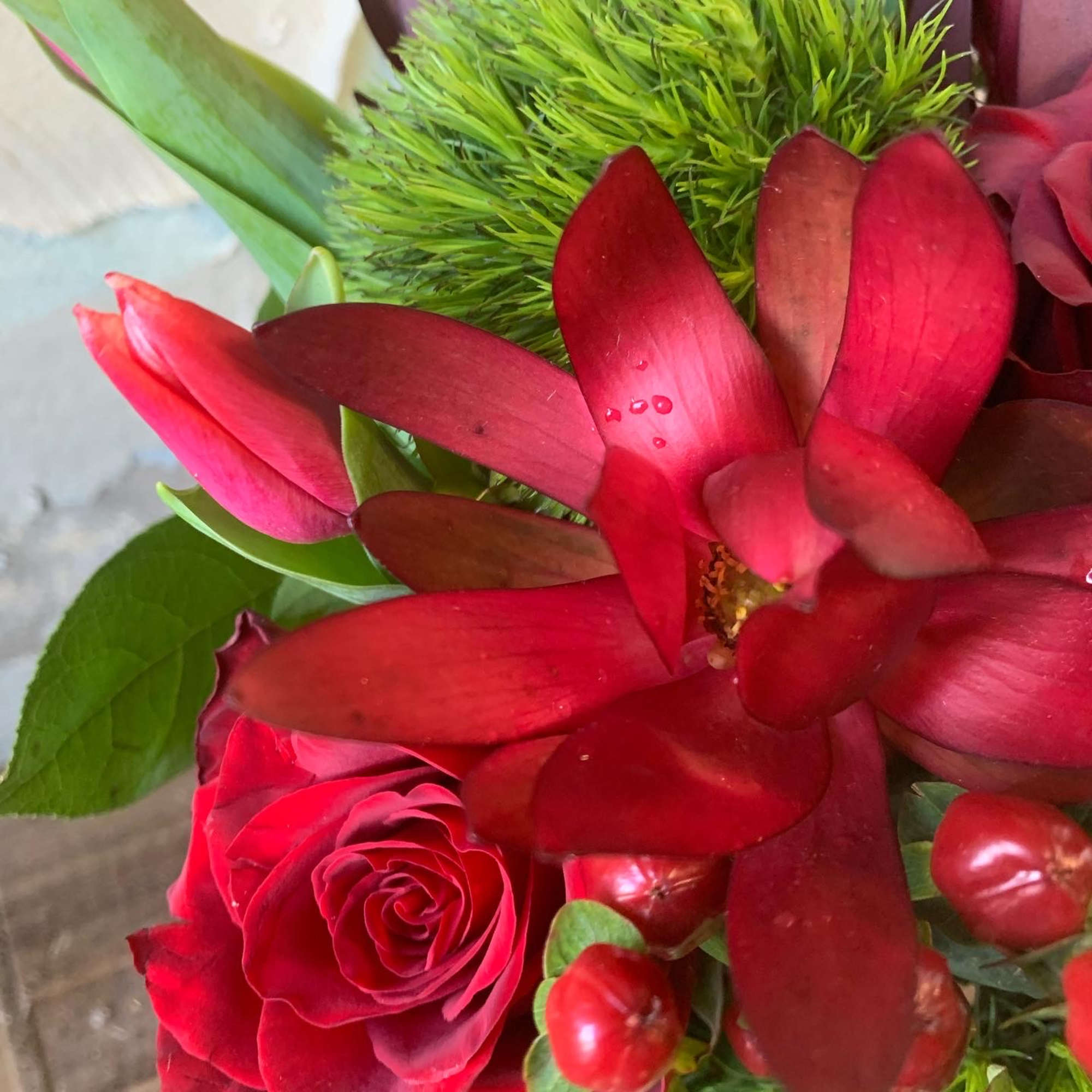 A festive Display of seasonal red roses, berries, balls and evergreens