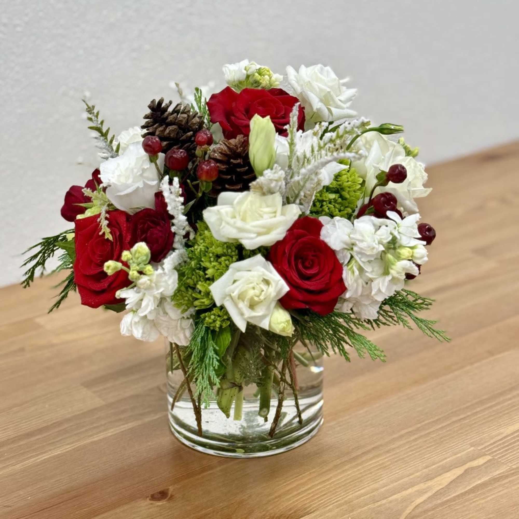 The winter flower arrangement features vibrant red roses, green hydrangeas, and white