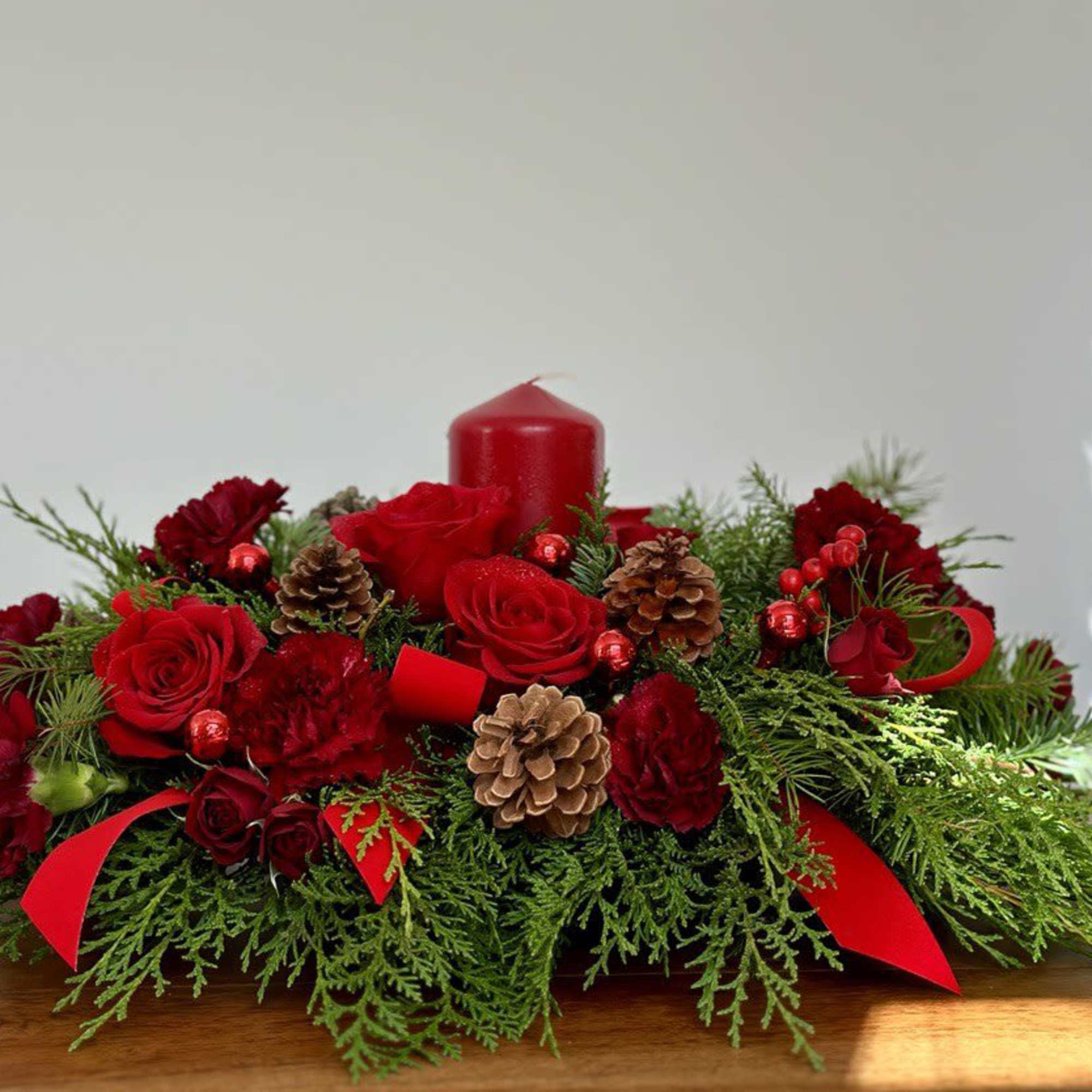 A lovely Christmas centerpiece enhanced by a red candle.





