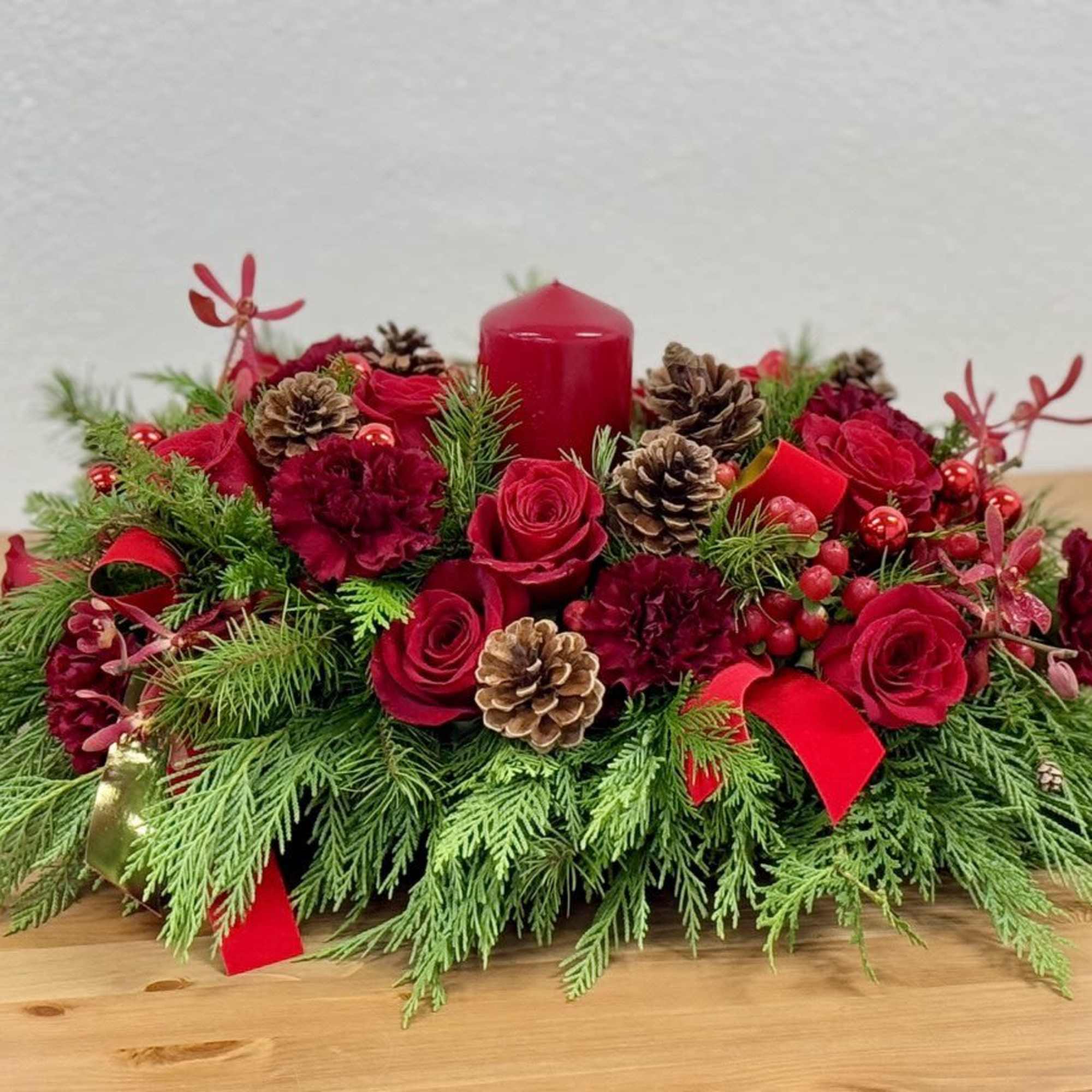 A lovely Christmas centerpiece enhanced by a red candle.





