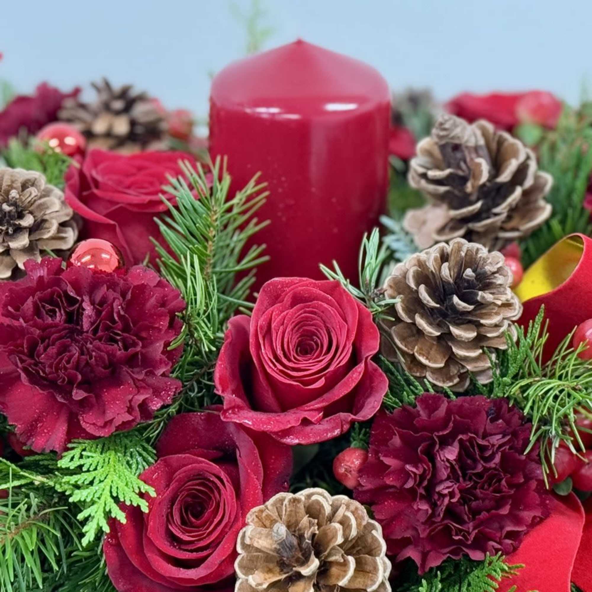 A lovely Christmas centerpiece enhanced by a red candle.





