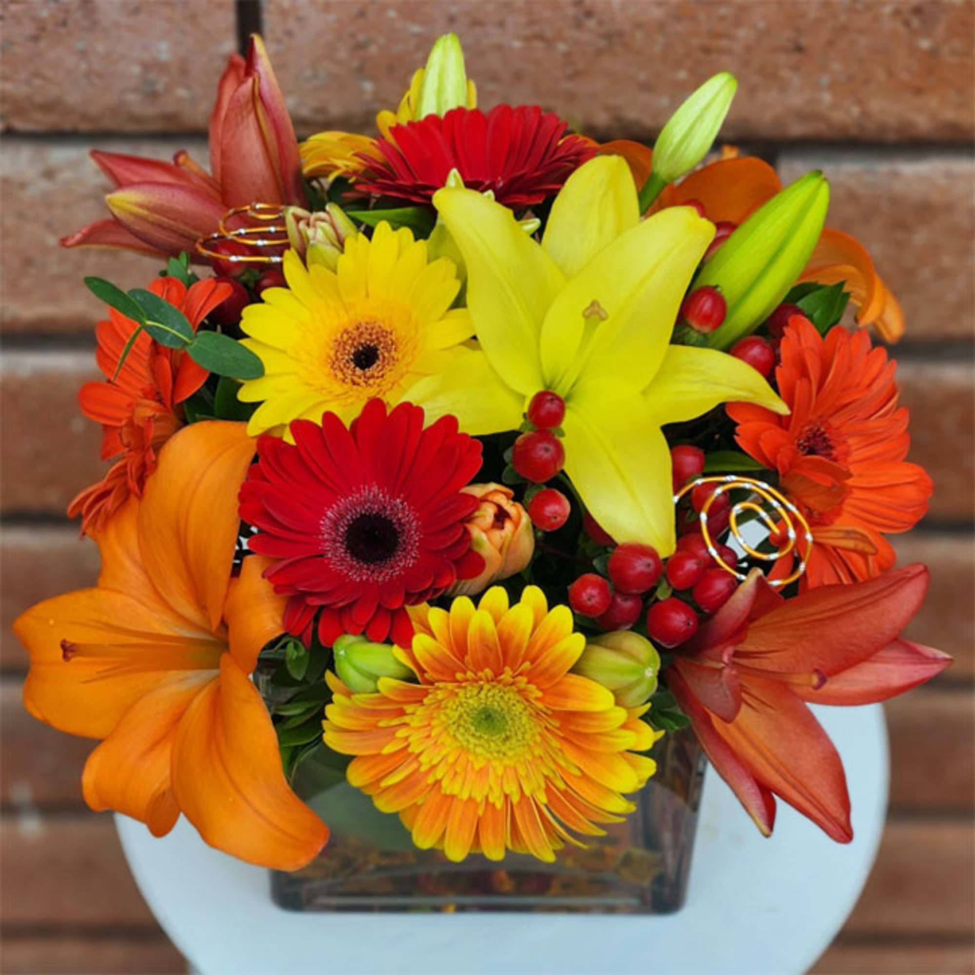 Royal Sunset Cube &ndash; Gerbera Daisies, Lilies &amp; Hypericum Berries

Bright, cheerful, and
