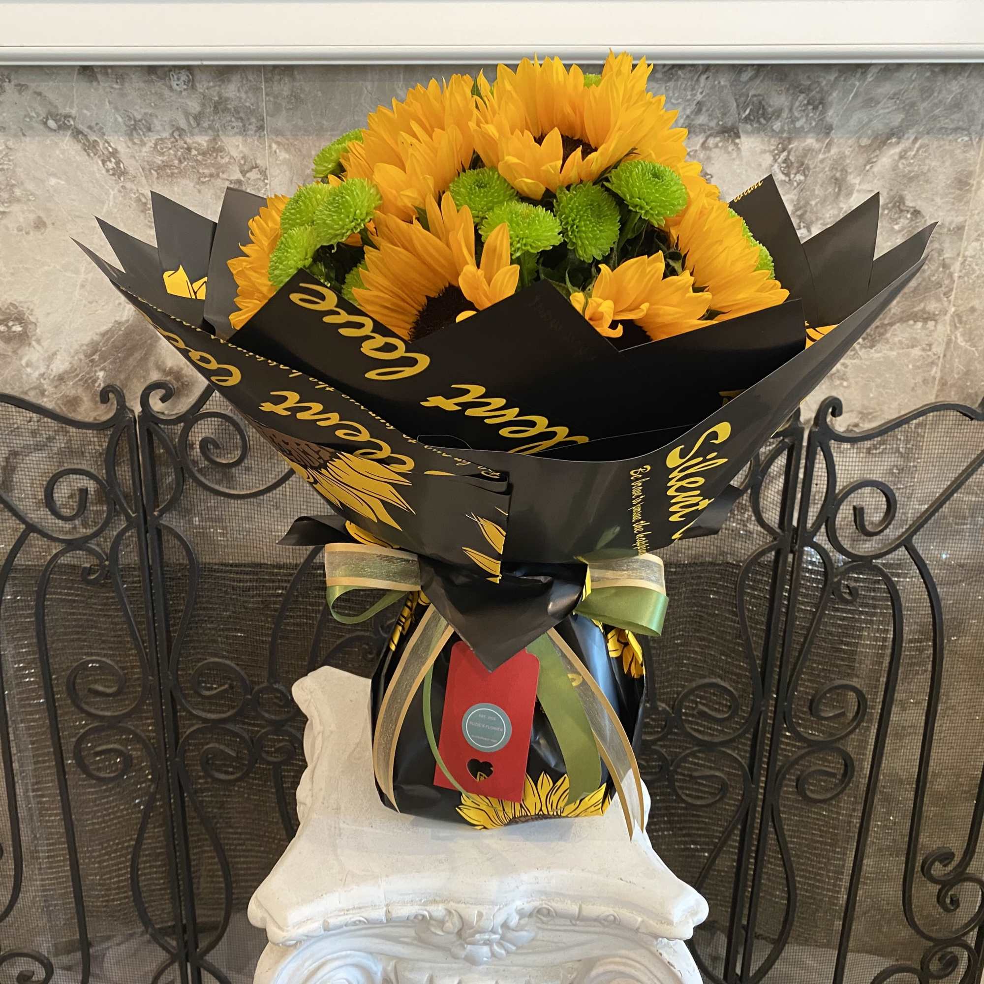 A Dozen Fresh Cut Sunflowers With Green Chrysanthemums In Waterproof Paper Bouquet.