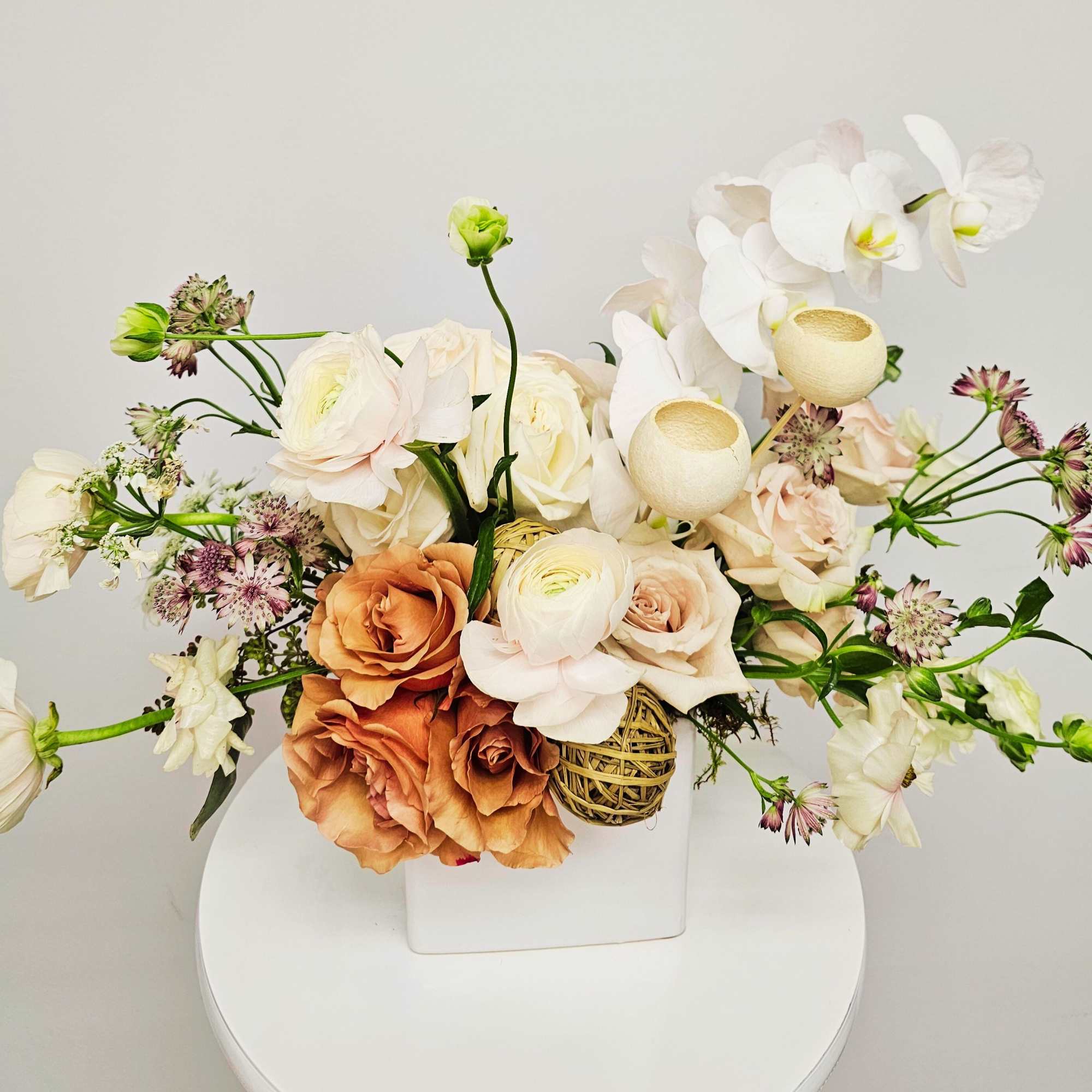 A curated modern design featuring roses, butterfly ranunculus and phalaenopsis orchids. 