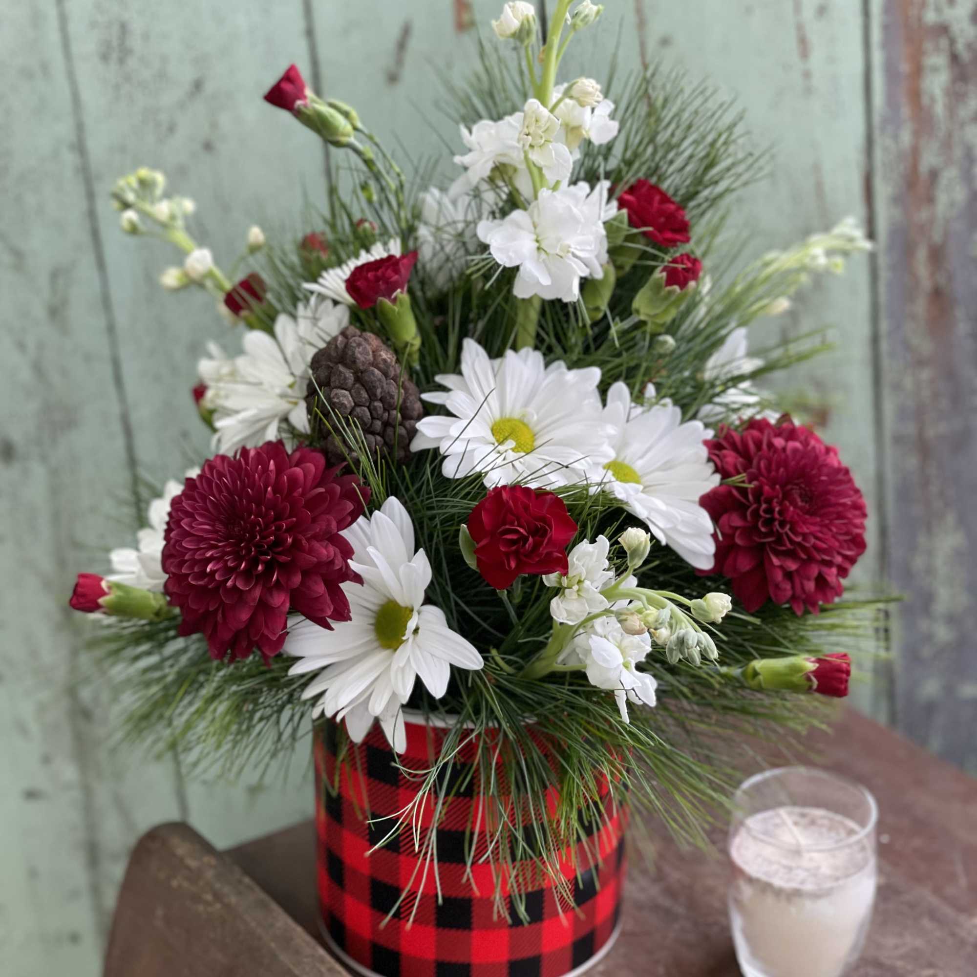 Send holiday greetings with this lovely evergreen arrangement in a ceramic buffalo