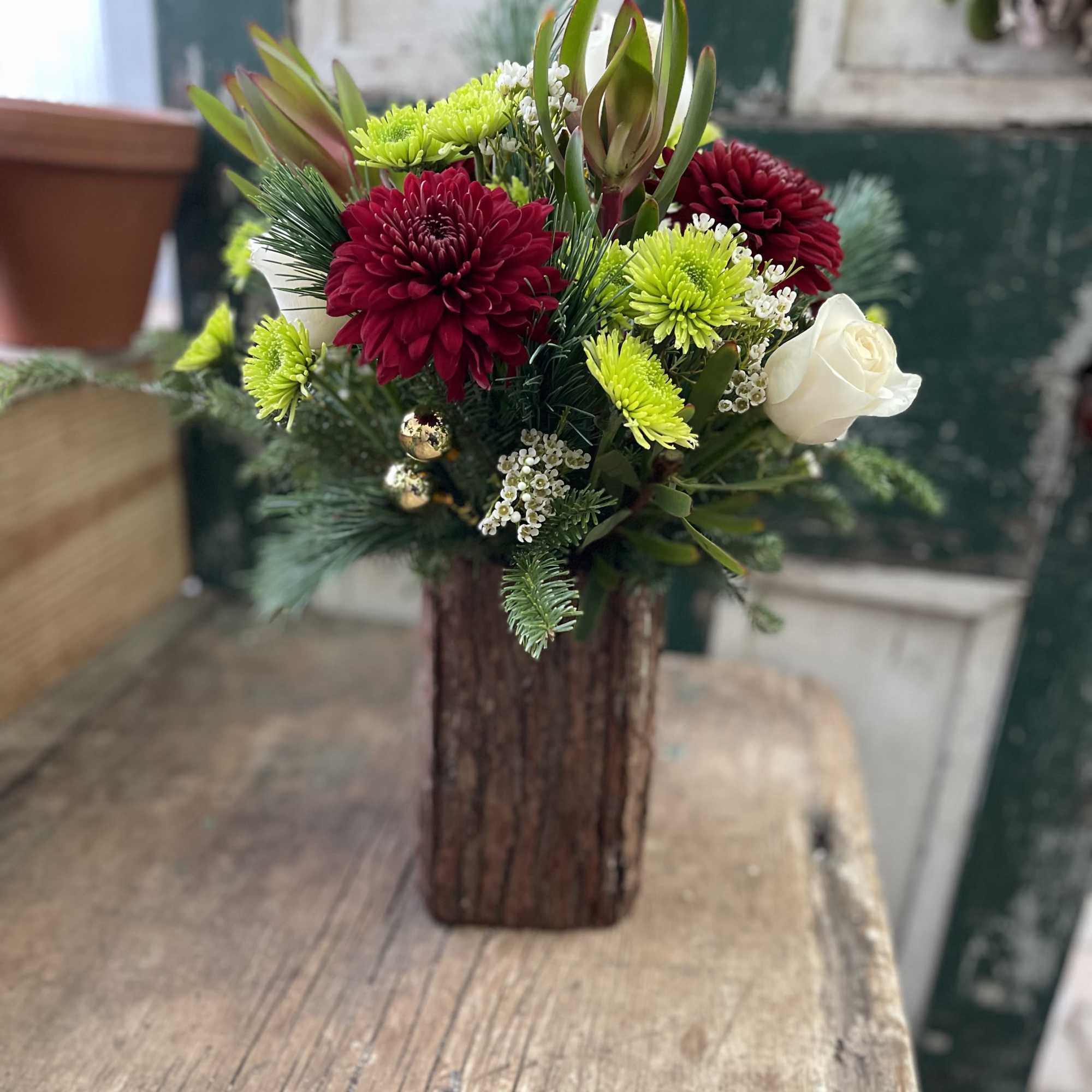 A holiday beauty in a rustic bark vase! This arrangement will be