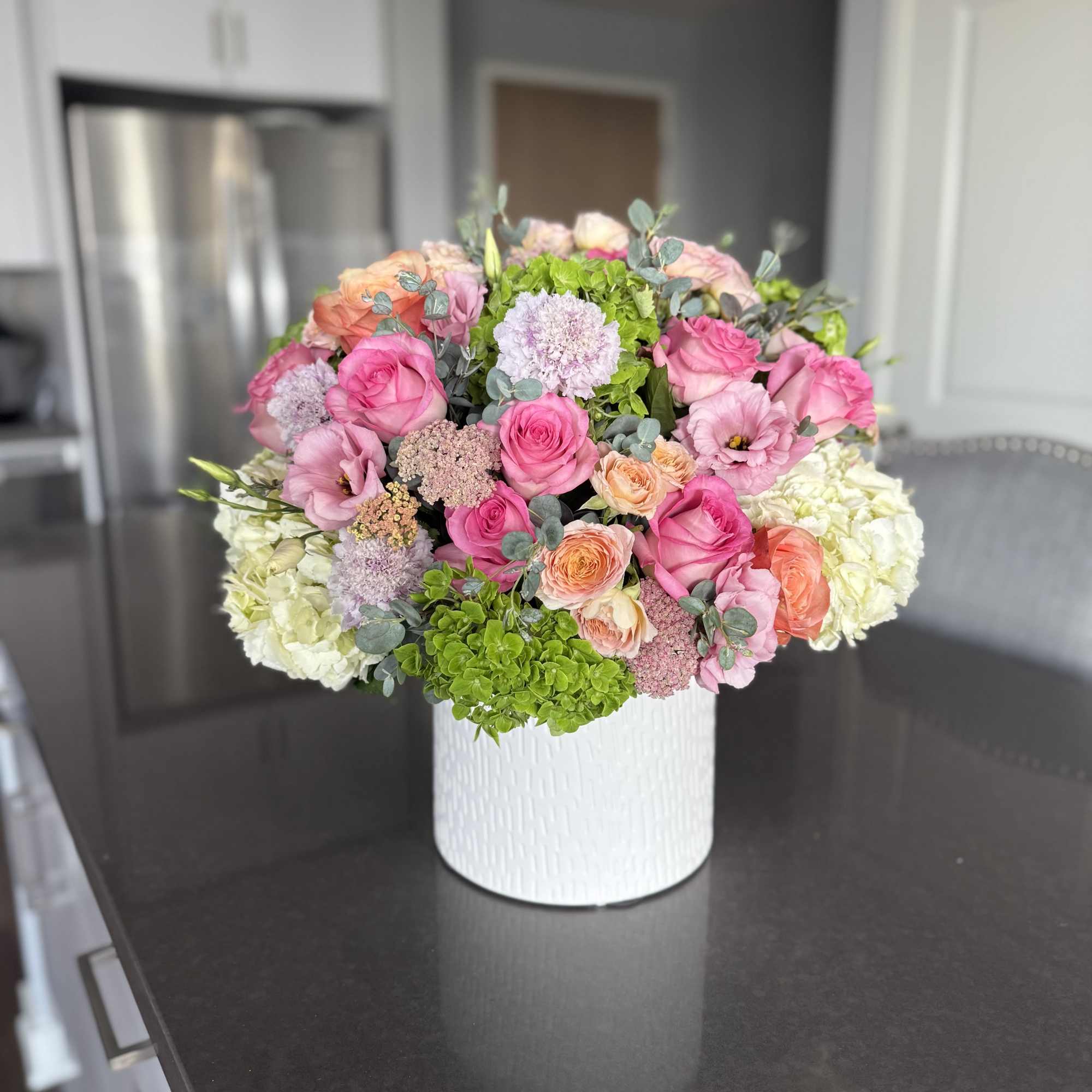 Radiating with charm and sophistication, Blushing Harmony is a lush floral arrangement