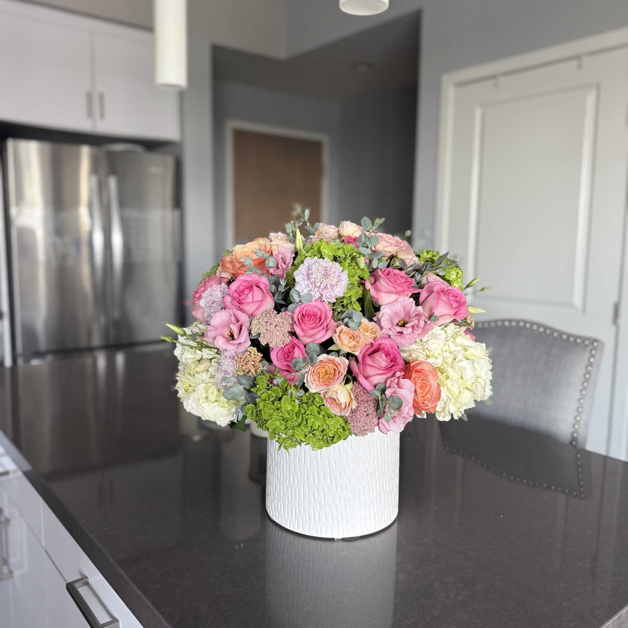 Radiating with charm and sophistication, Blushing Harmony is a lush floral arrangement