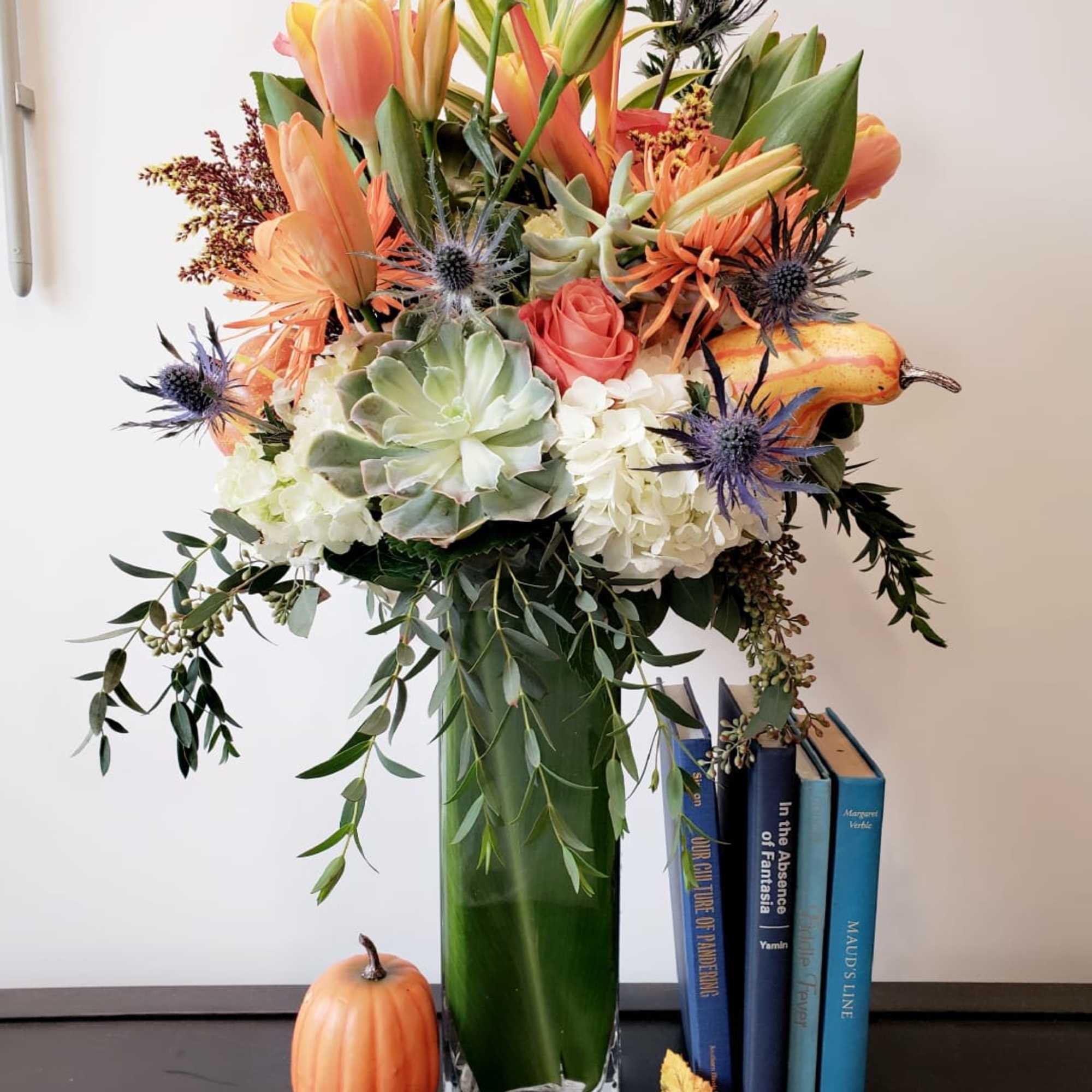 Amazing fall flowers set in a tall glass vase accent with fall