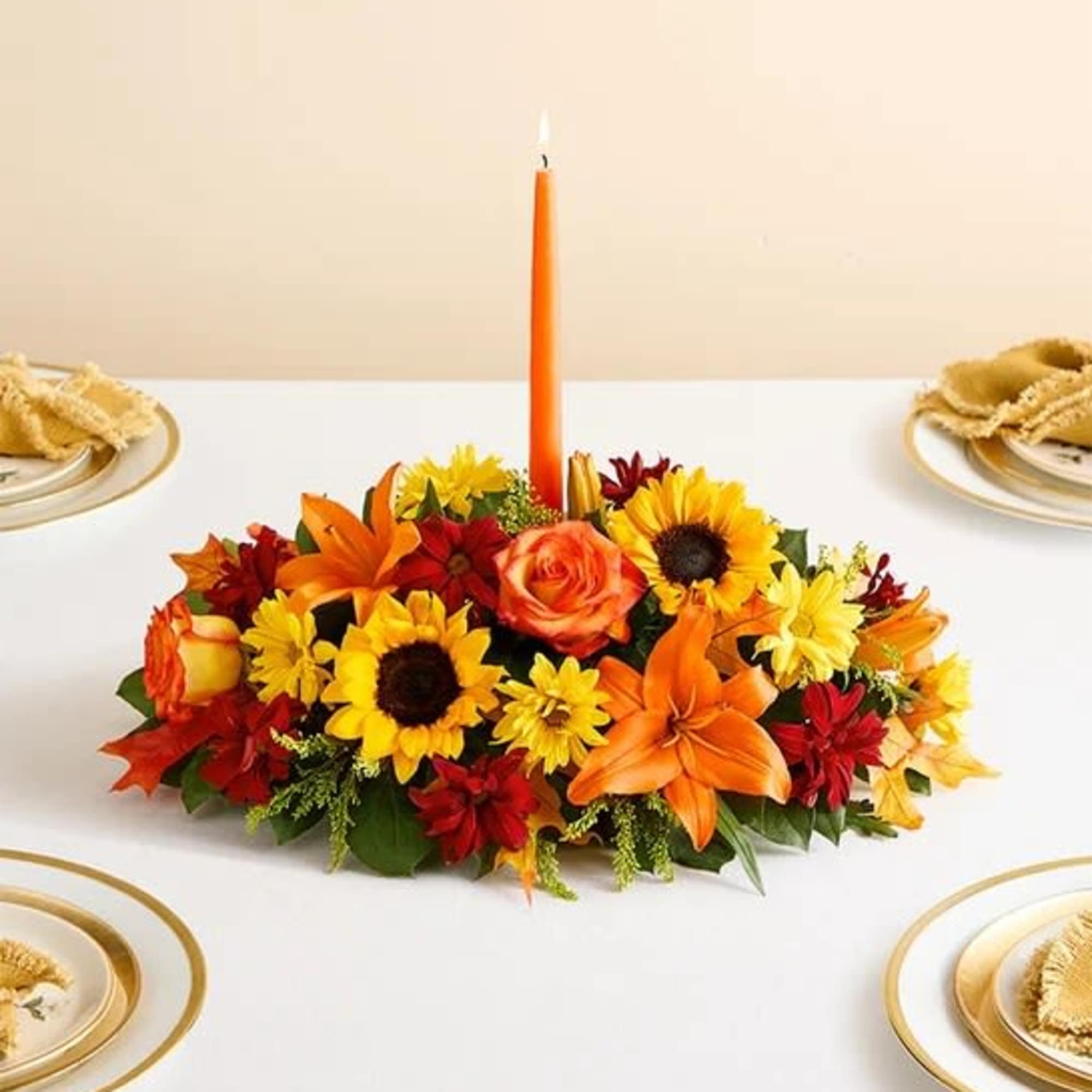 All-around arrangement with autumn-colored roses, sunflowers, red daisy poms, orange Asiatic lilies;