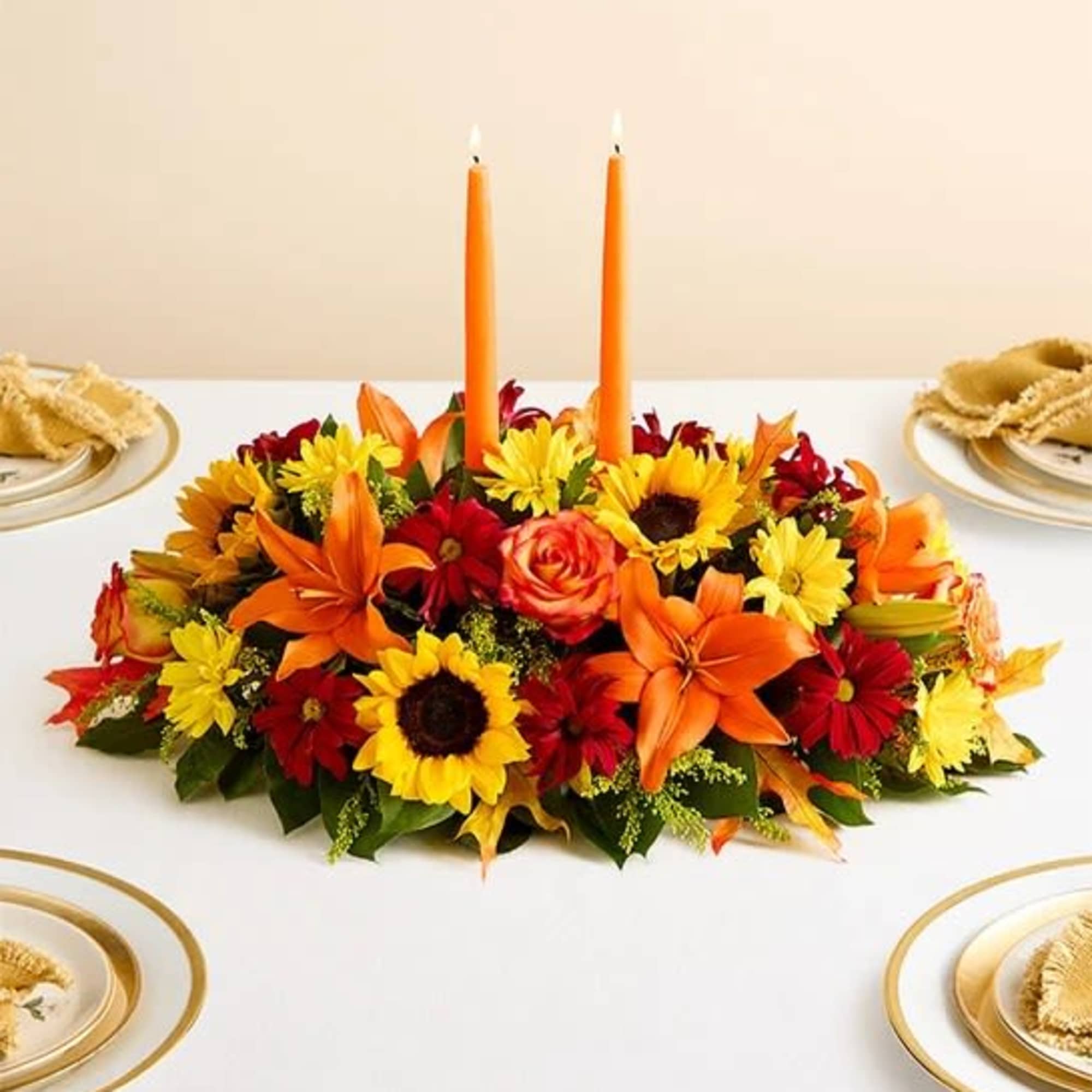 All-around arrangement with autumn-colored roses, sunflowers, red daisy poms, orange Asiatic lilies;