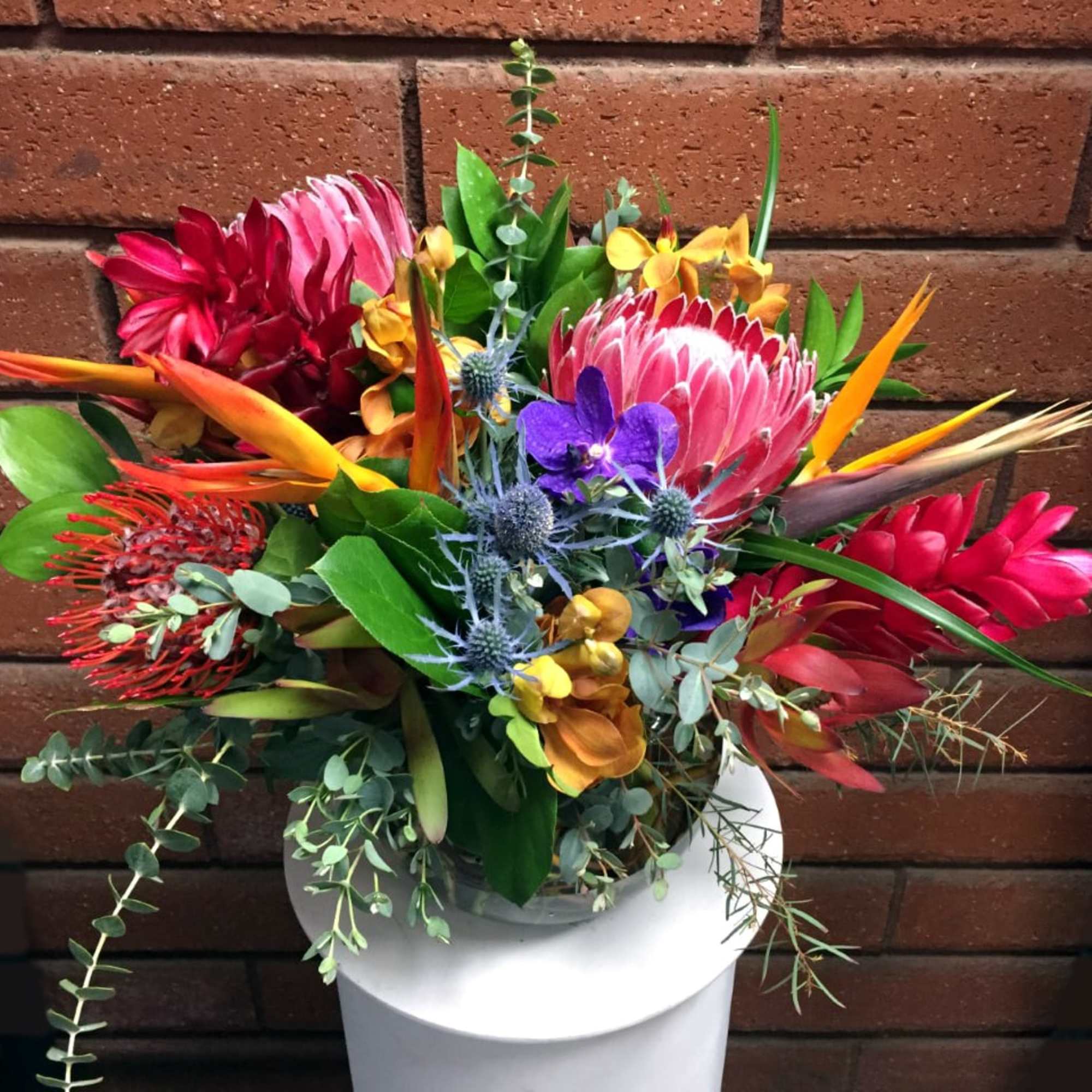 Escape to the islands with this tropical display of flowers, featuring vibrant