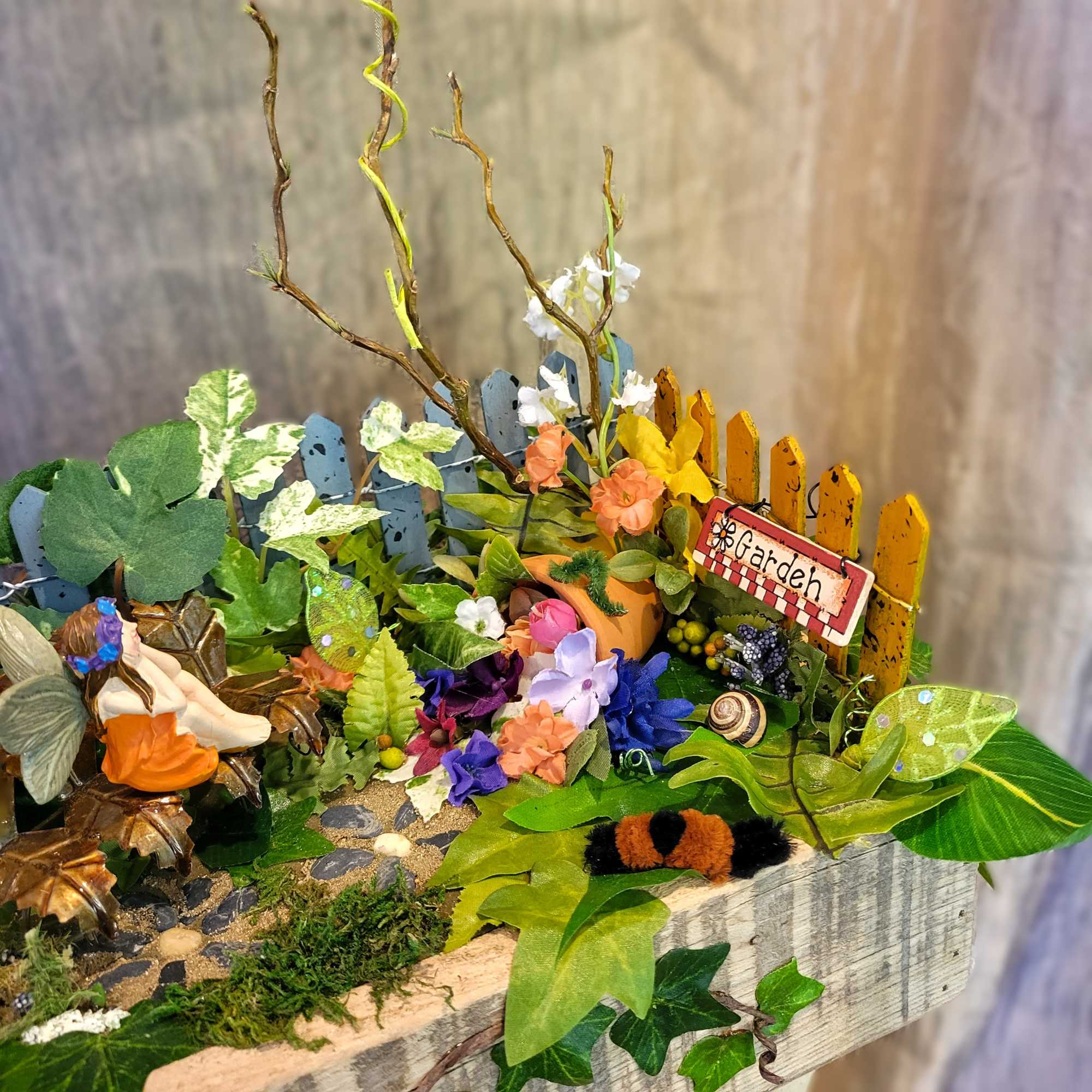 This artificial fairy garden contains multitudes! Examine it closer and find more