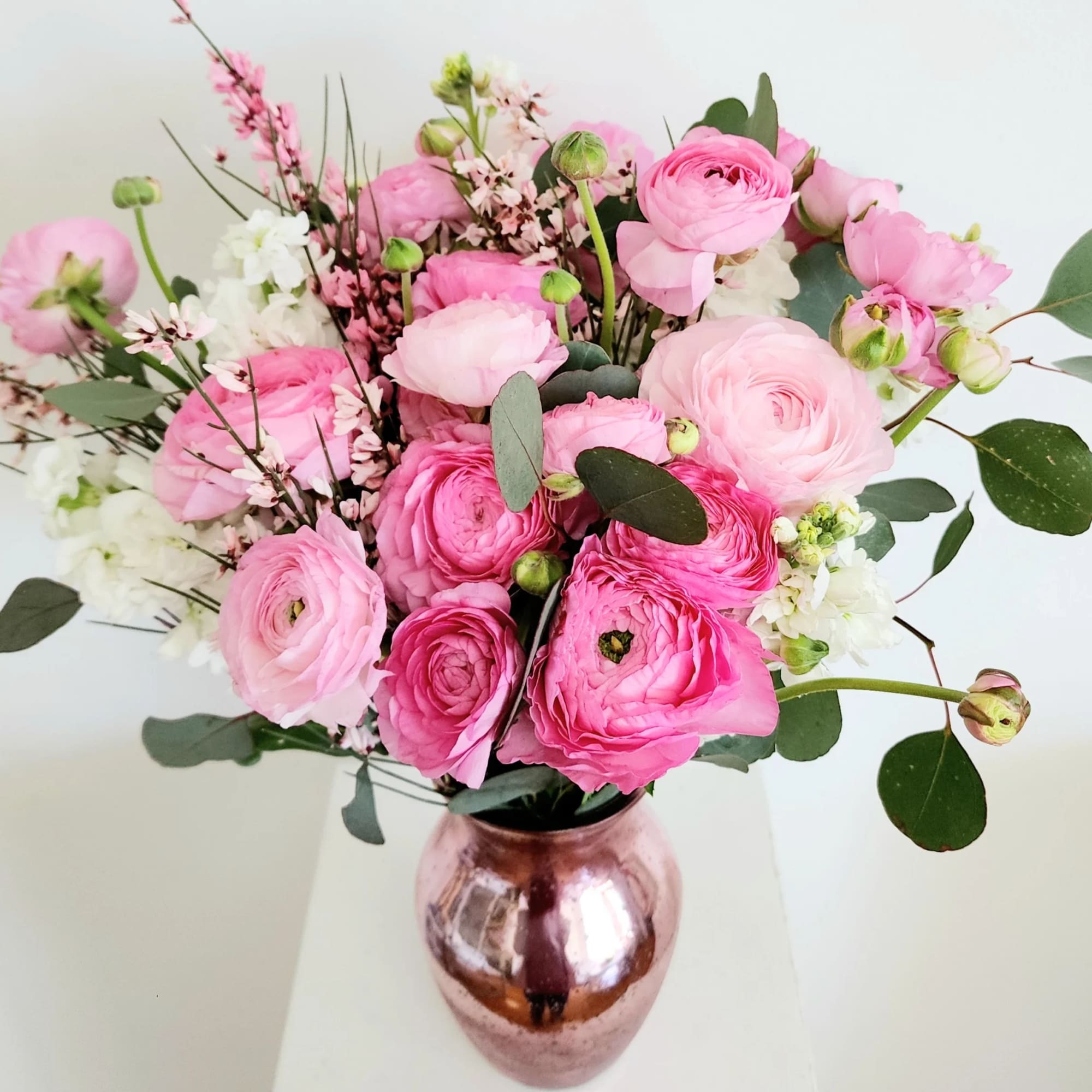 Several stems of ranunculus with white roses or stock flower, and pink