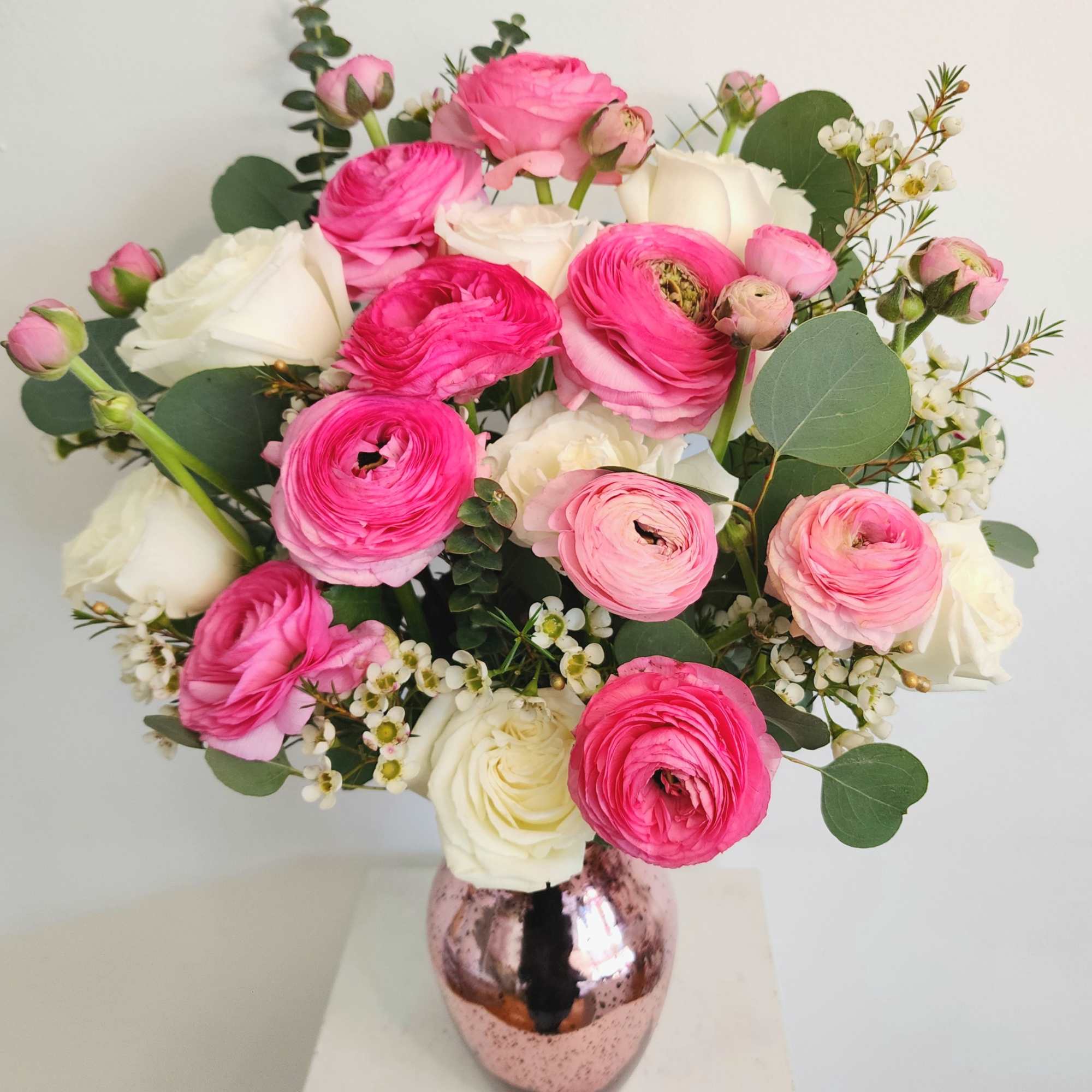 Several stems of ranunculus with white roses or stock flower, and pink
