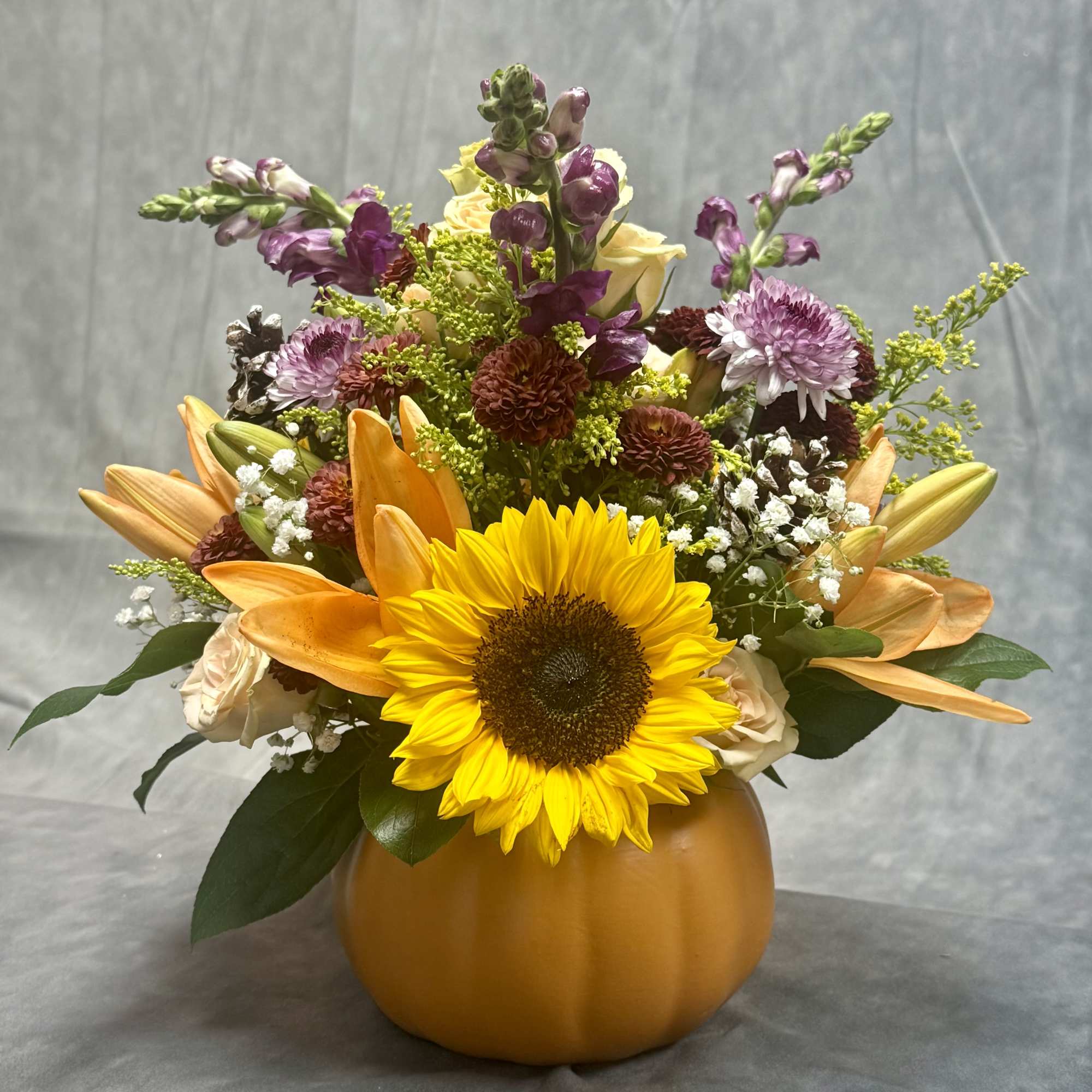 Bring fall into your home with this vibrant pumpkin arrangement filled with