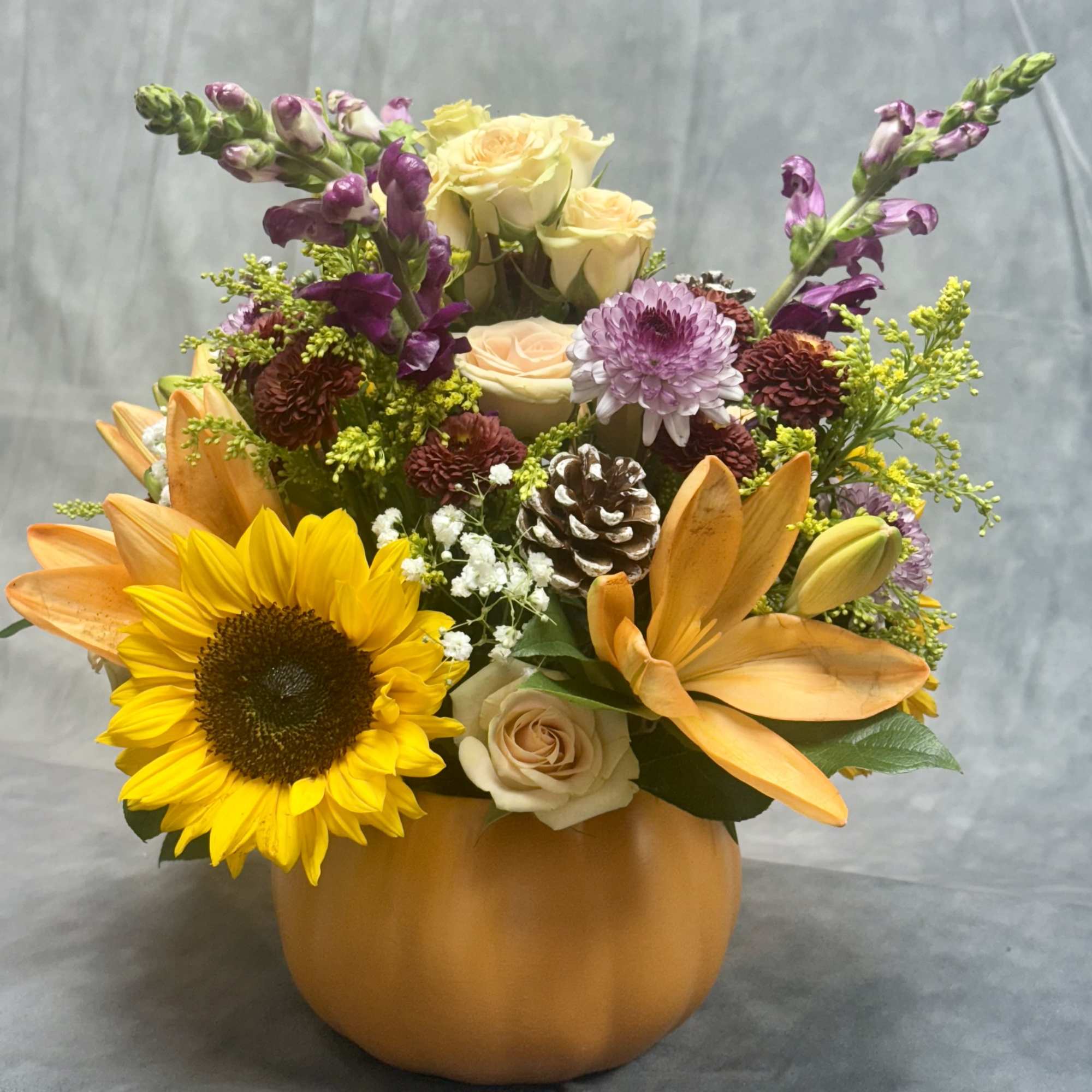 Bring fall into your home with this vibrant pumpkin arrangement filled with