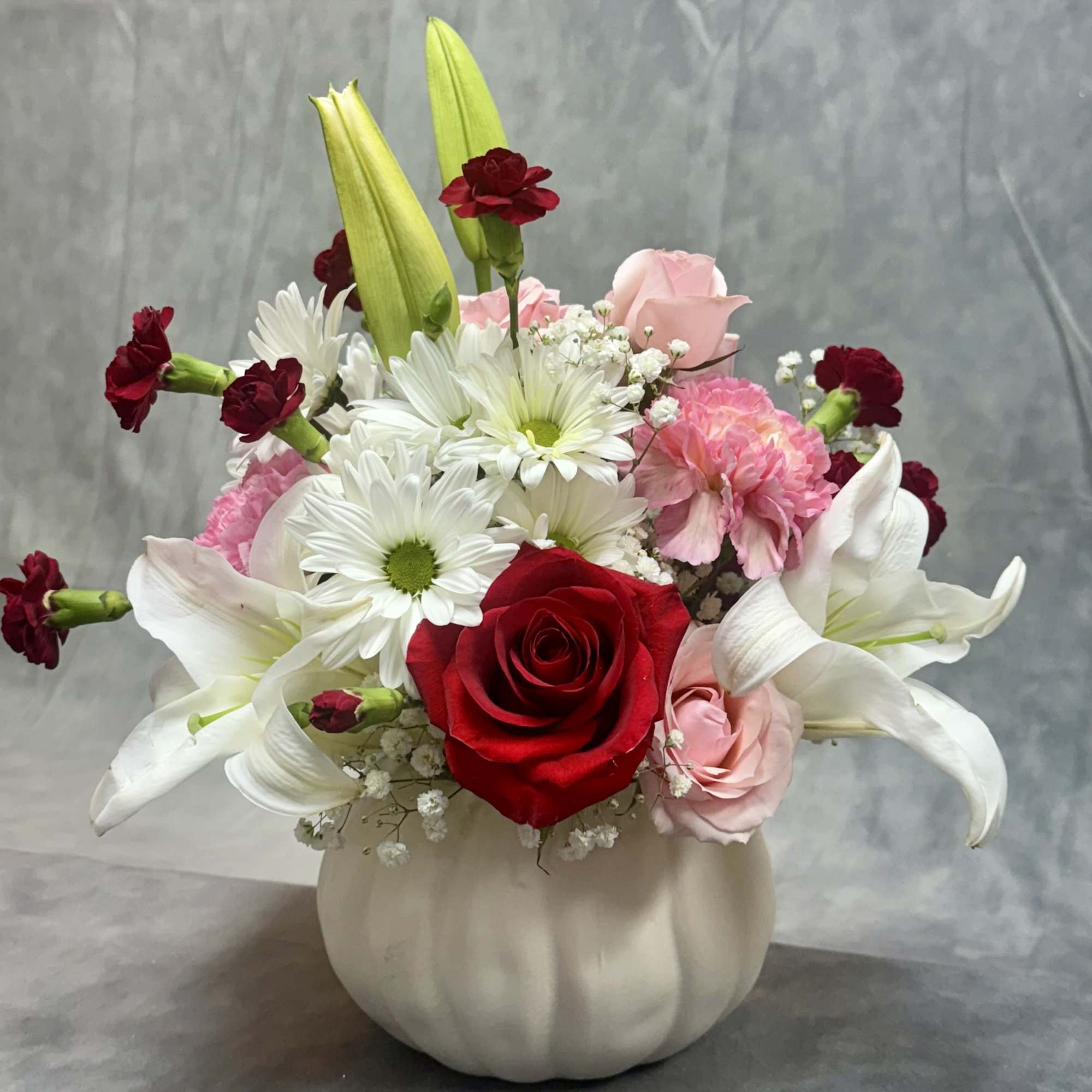 A soft and romantic mix of lilies, roses, daisies, and mini carnations