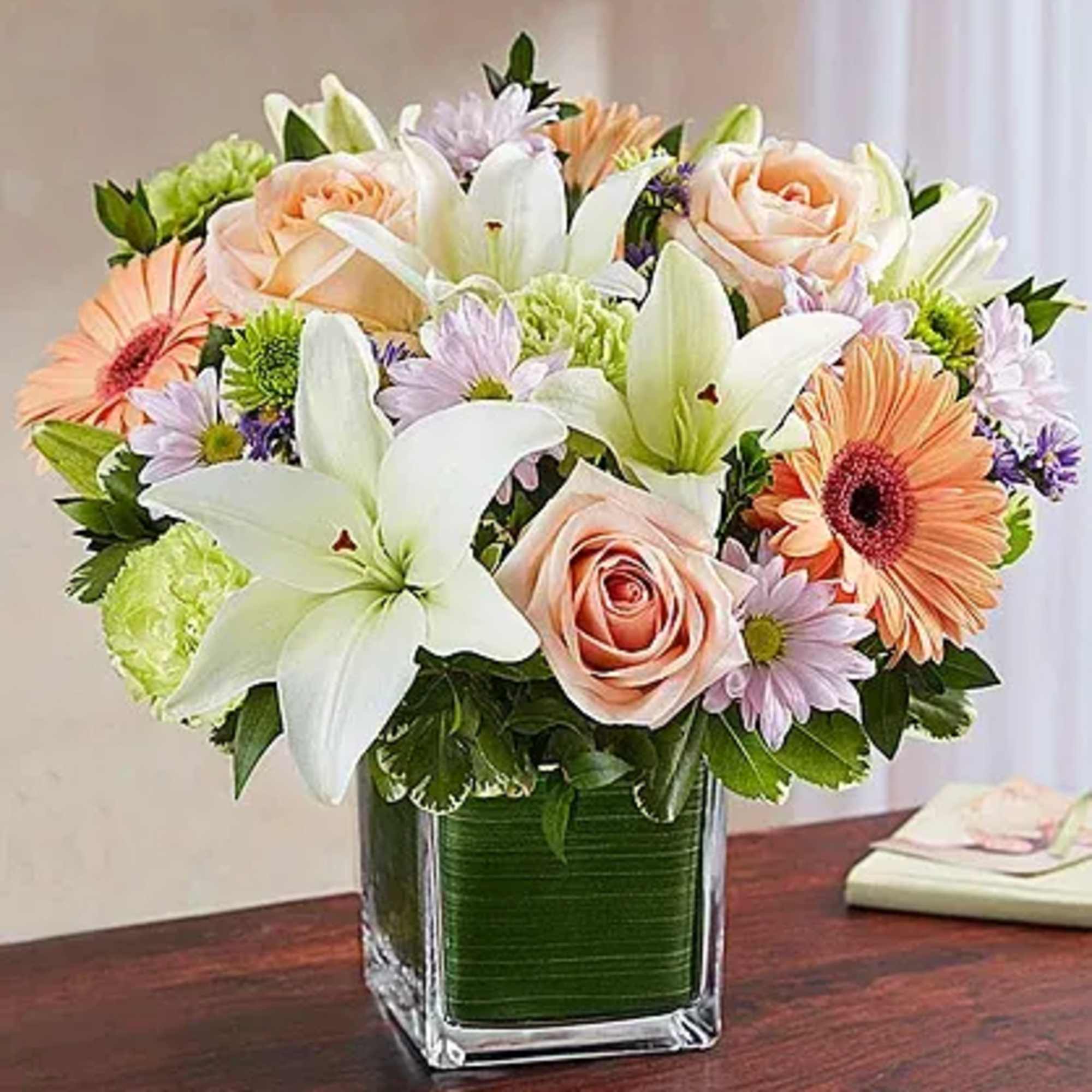 Arrangement of white roses, Asiatic lilies, football mums, snapdragon, daisy poms and