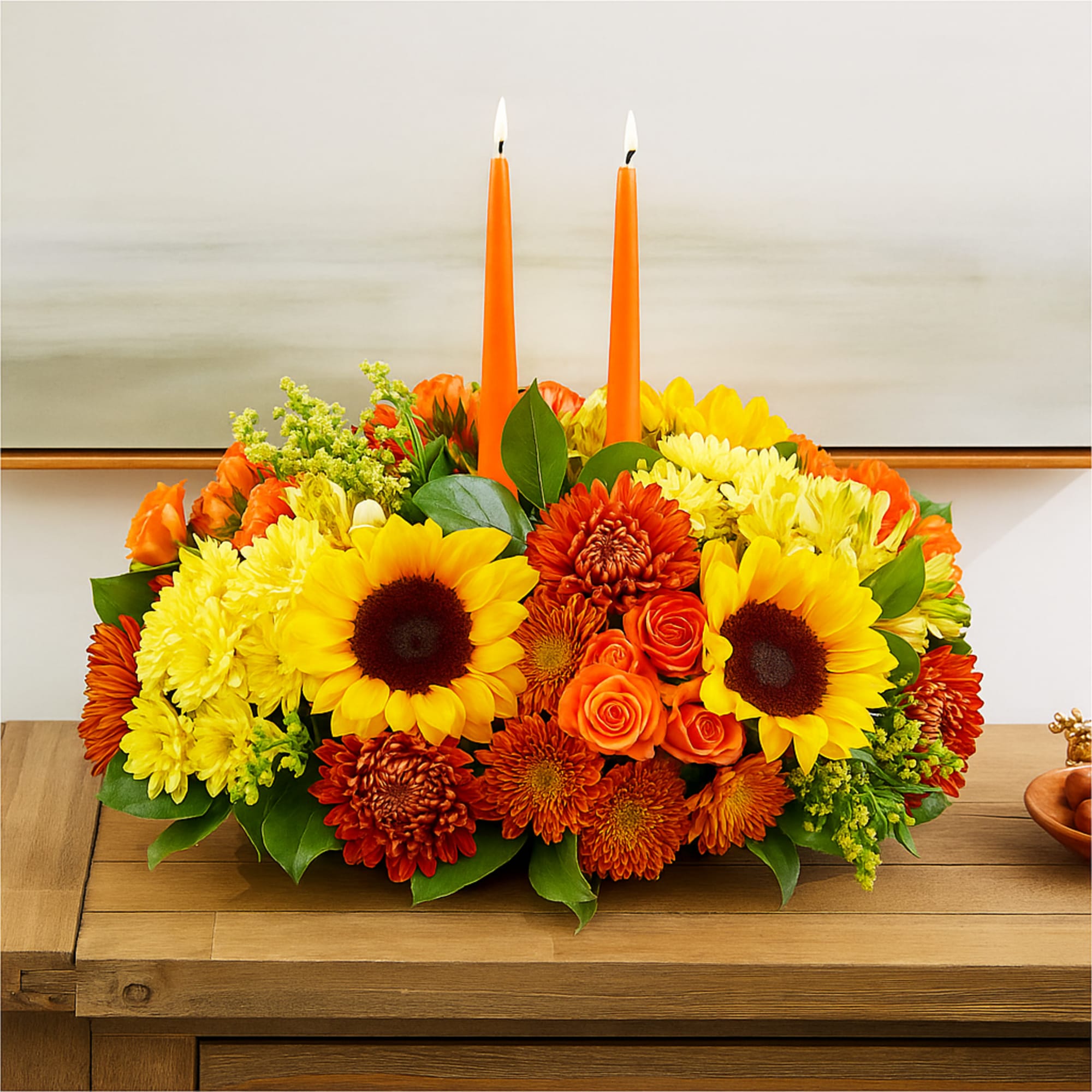 Warm sunflowers, amber mums, and glowing roses come together around twin taper