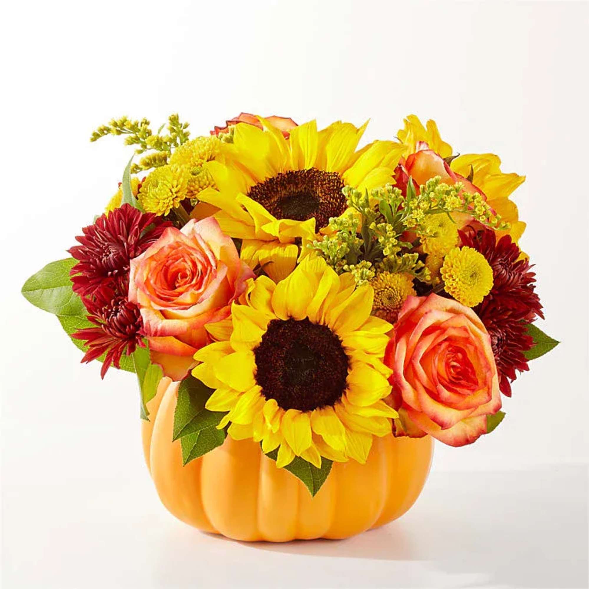 Golden sunflowers burst from a softly sculpted pumpkin vessel, embracing autumn&rsquo;s warm
