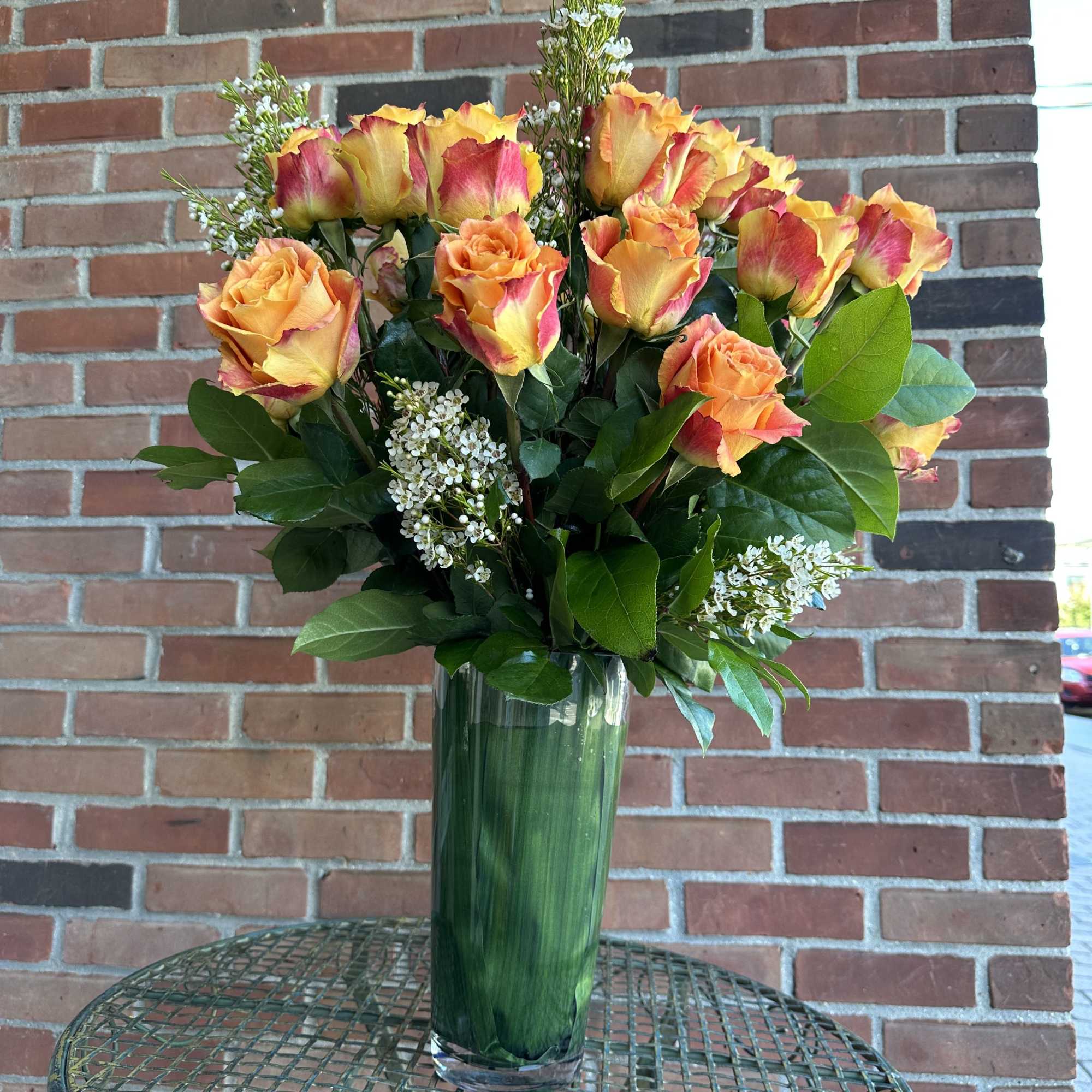 Deluxe orange roses in beautiful vases 
**Standard version** Dozen Long-stemmed roses 
**Deluxe