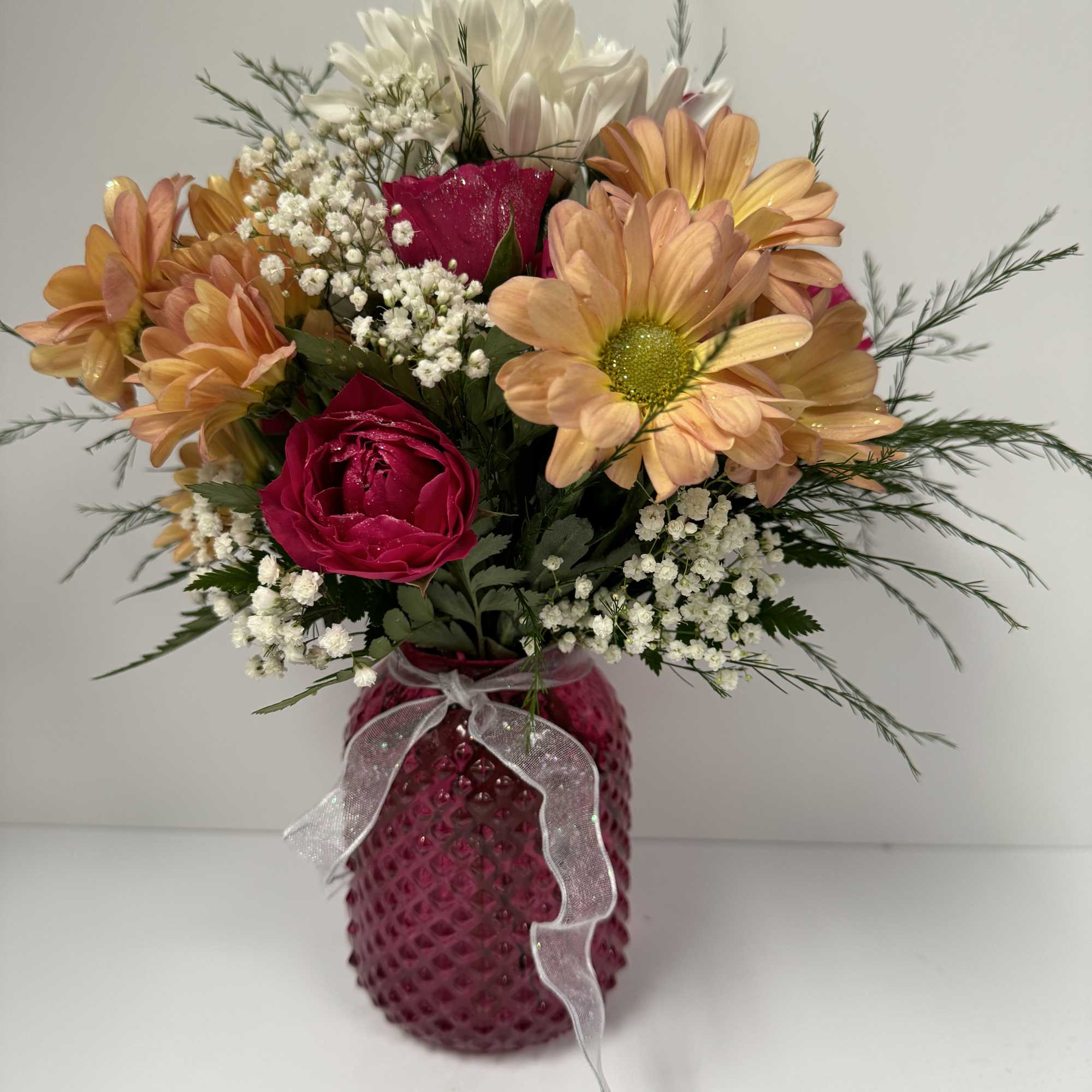 Simple Sparkled Daisies and spray roses in a sweet knobby vase. Simple