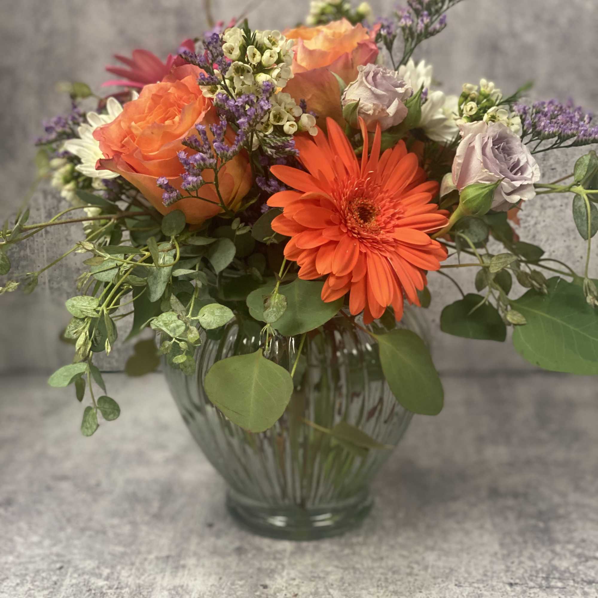 Stunning roses, Gerbera Daisies and Cushion mums with seasonal filler make a