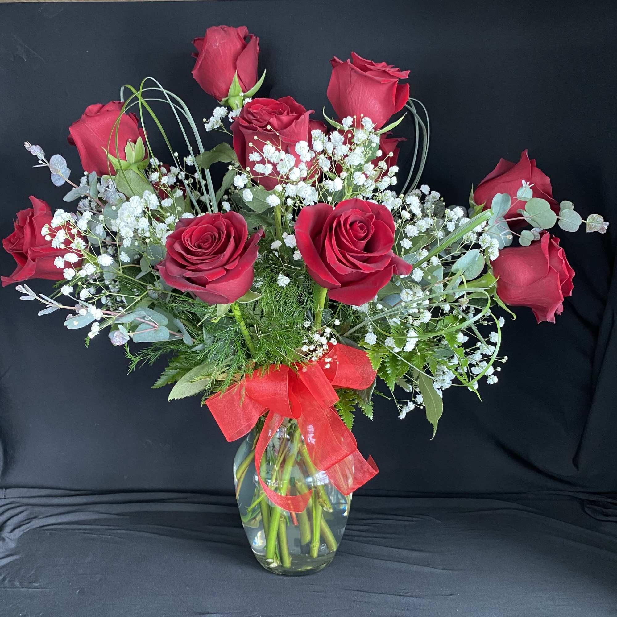 A charming bouquet of a dozen fresh and fragrant red roses, adorned
