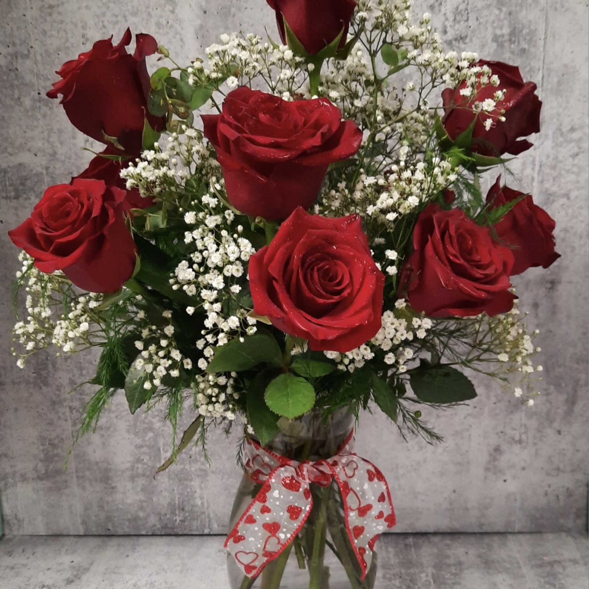 A charming bouquet of a dozen fresh and fragrant red roses, adorned