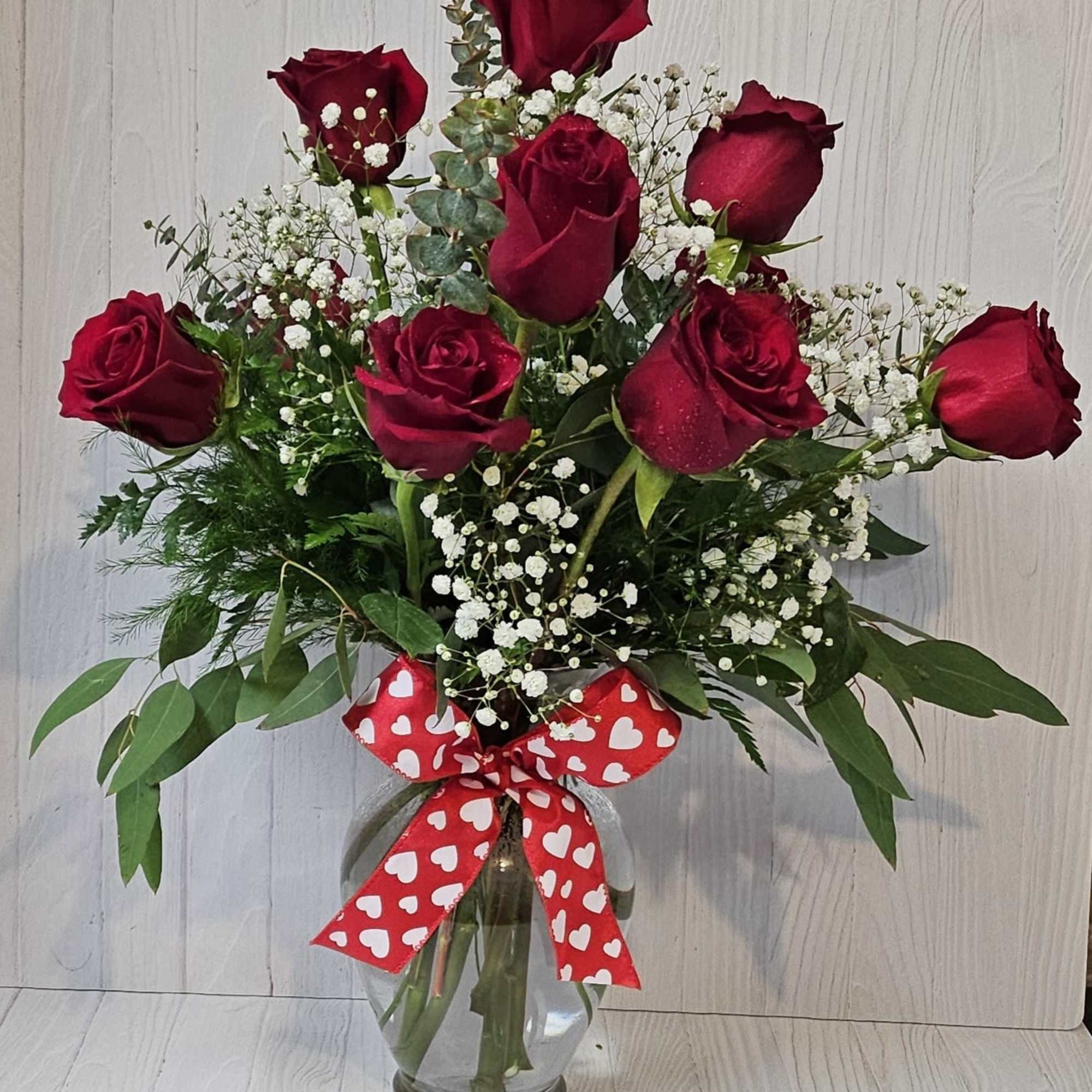 A charming bouquet of a dozen fresh and fragrant red roses, adorned